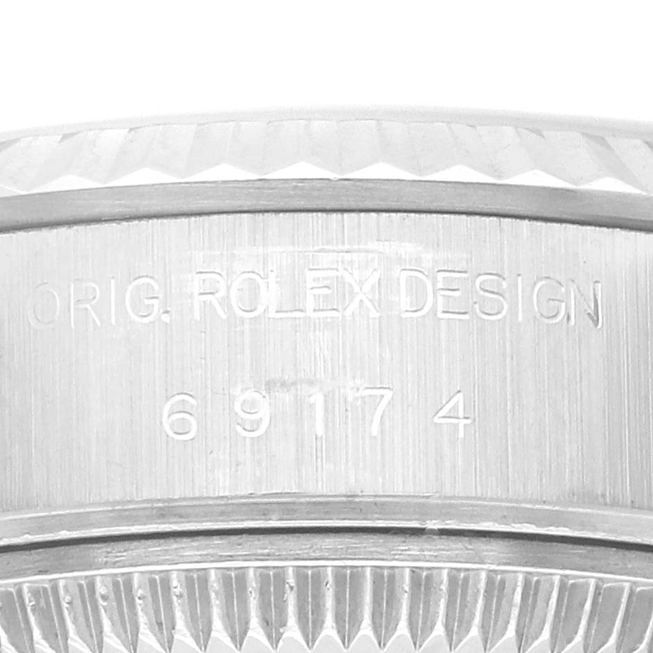 The image shows a close-up of the side of a Rolex Datejust 69174 Women's Stainless Steel White Dial 69174 Women's Stainless Steel White Dial watch case, featuring the model number and "Orig. Rolex Design" engraving.