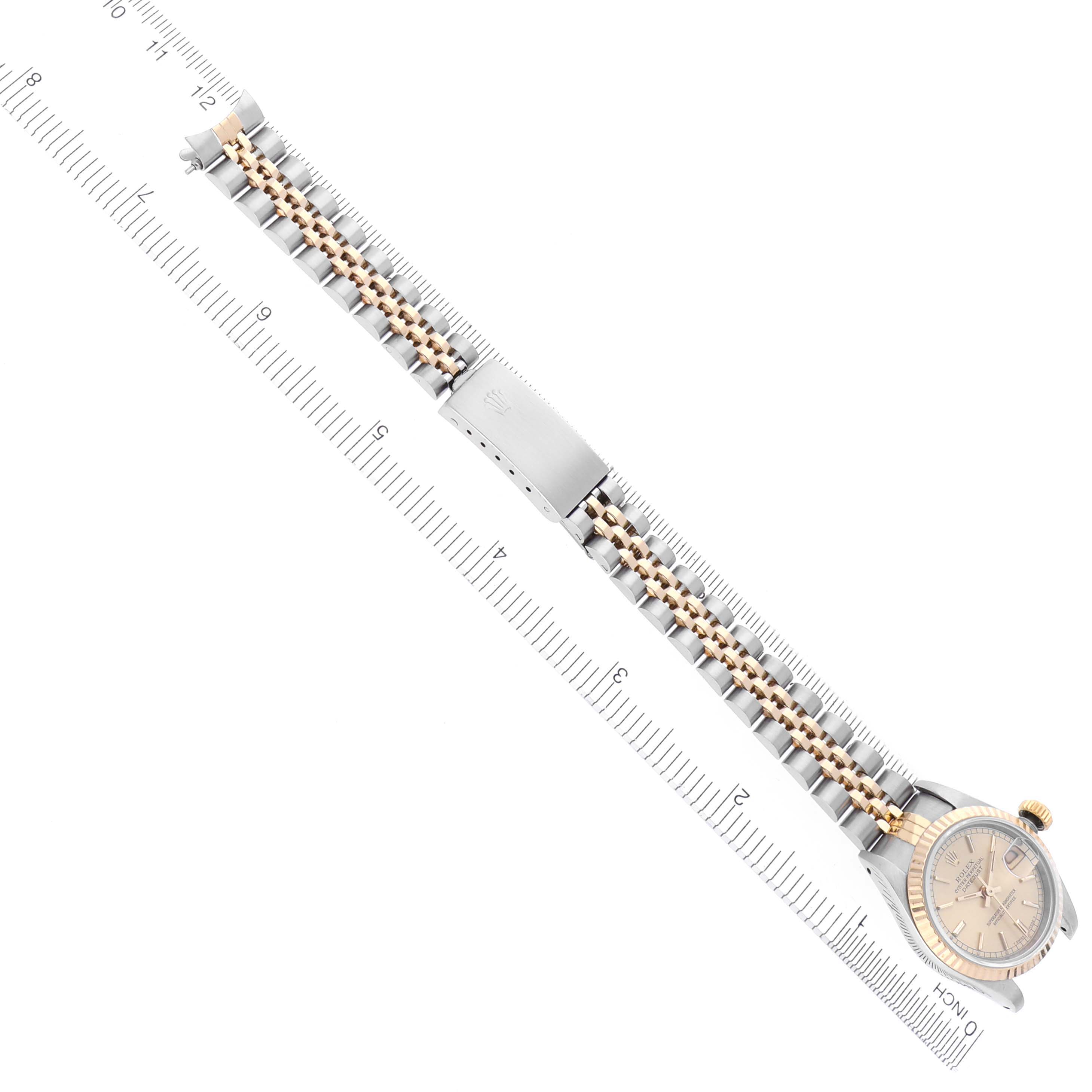 The image shows a top view of a Rolex Datejust 69173 Women's Steel and Gold (two tone) Champagne Dial 69173 Women's Steel and Gold (two tone) Champagne Dial with its bracelet extended along a ruler.