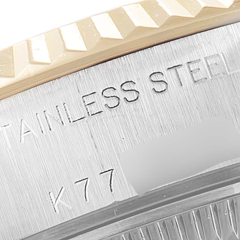 The image shows a close-up of the side of the Rolex Datejust 79173 Women
s Steel and Gold (two tone) Champagne Dial 79173 Women
s Steel and Gold (two tone) Champagne Dial watch with part of the fluted bezel and "STAINLESS STEEL" engraving visible.