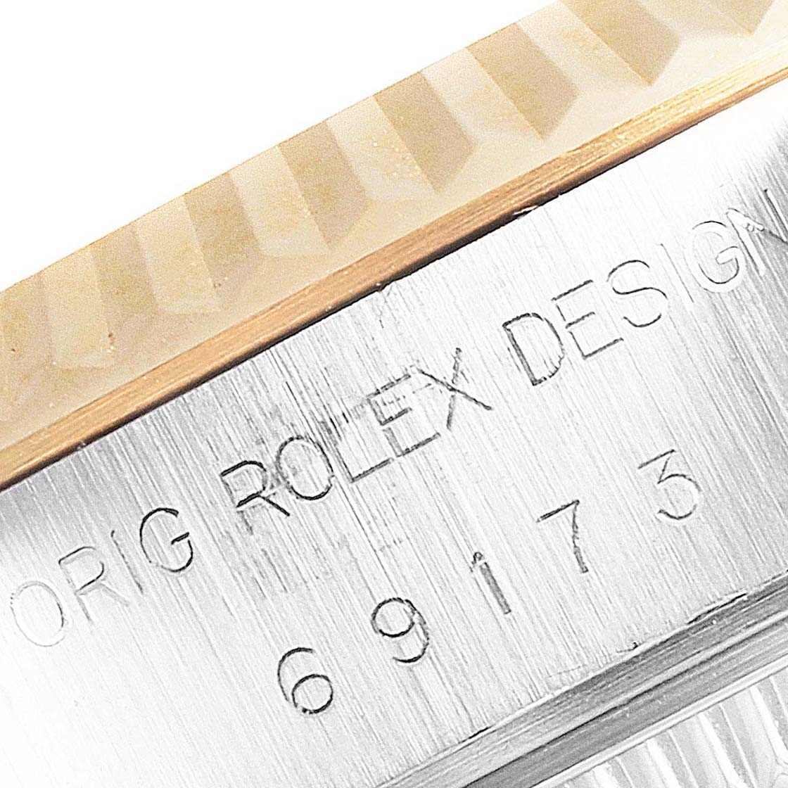 This close-up of a Rolex Datejust 69173 Women
s Steel and Gold (two tone) Champagne Dial 69173 Women
s Steel and Gold (two tone) Champagne Dial watch shows the edge of the case and the engraved model number.