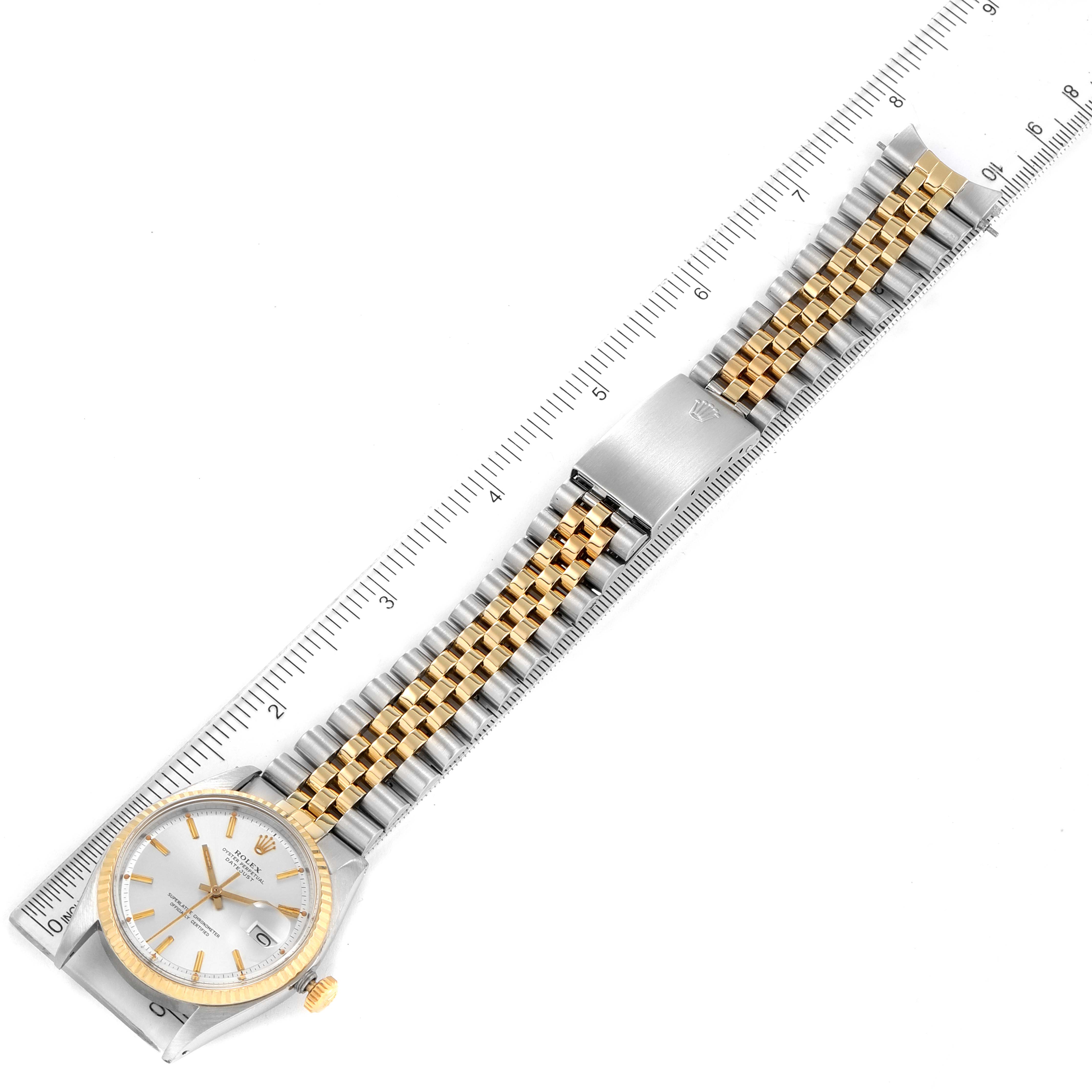 The Vintage Collection Rolex watch is shown from an aerial view, displaying the face, crown, and bracelet fully extended along a ruler.