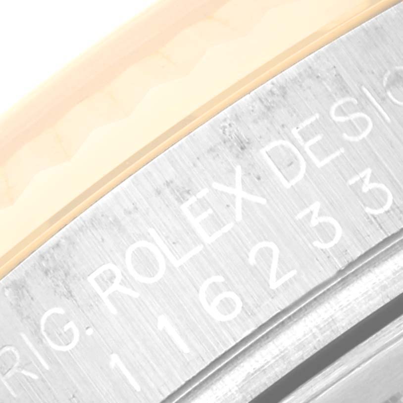 This close-up image of a Rolex Datejust 116233 Men's Steel and Gold (two tone) Silver Dial 116233 Men's Steel and Gold (two tone) Silver Dial watch shows part of the case edge, detailing the engraving.