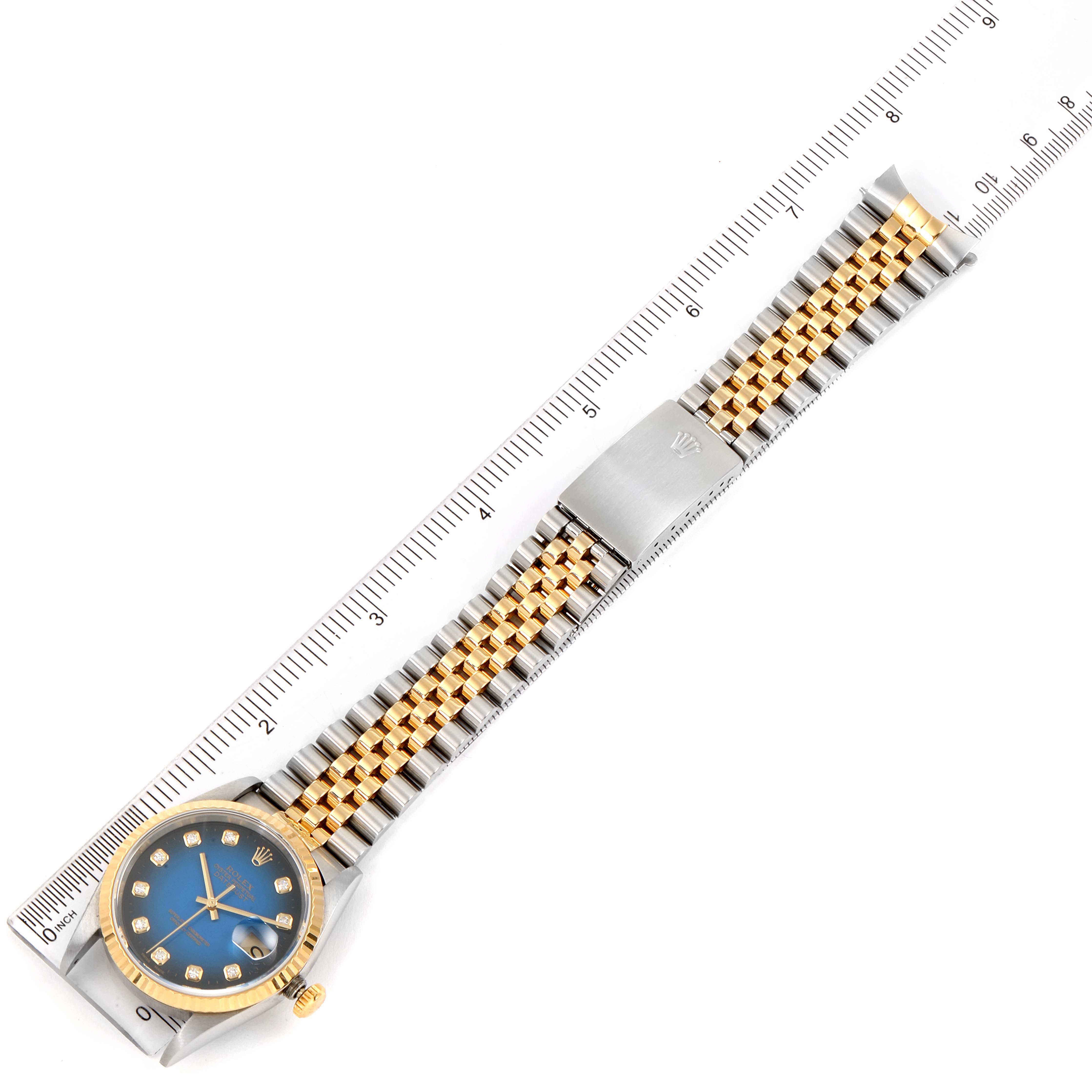 The Rolex Datejust 16233 Men's Steel and Gold (two tone) Blue Dial 16233 Men's Steel and Gold (two tone) Blue Dial watch is shown horizontally, displaying the face, bezel, crown, and metal bracelet with ruler for scale.