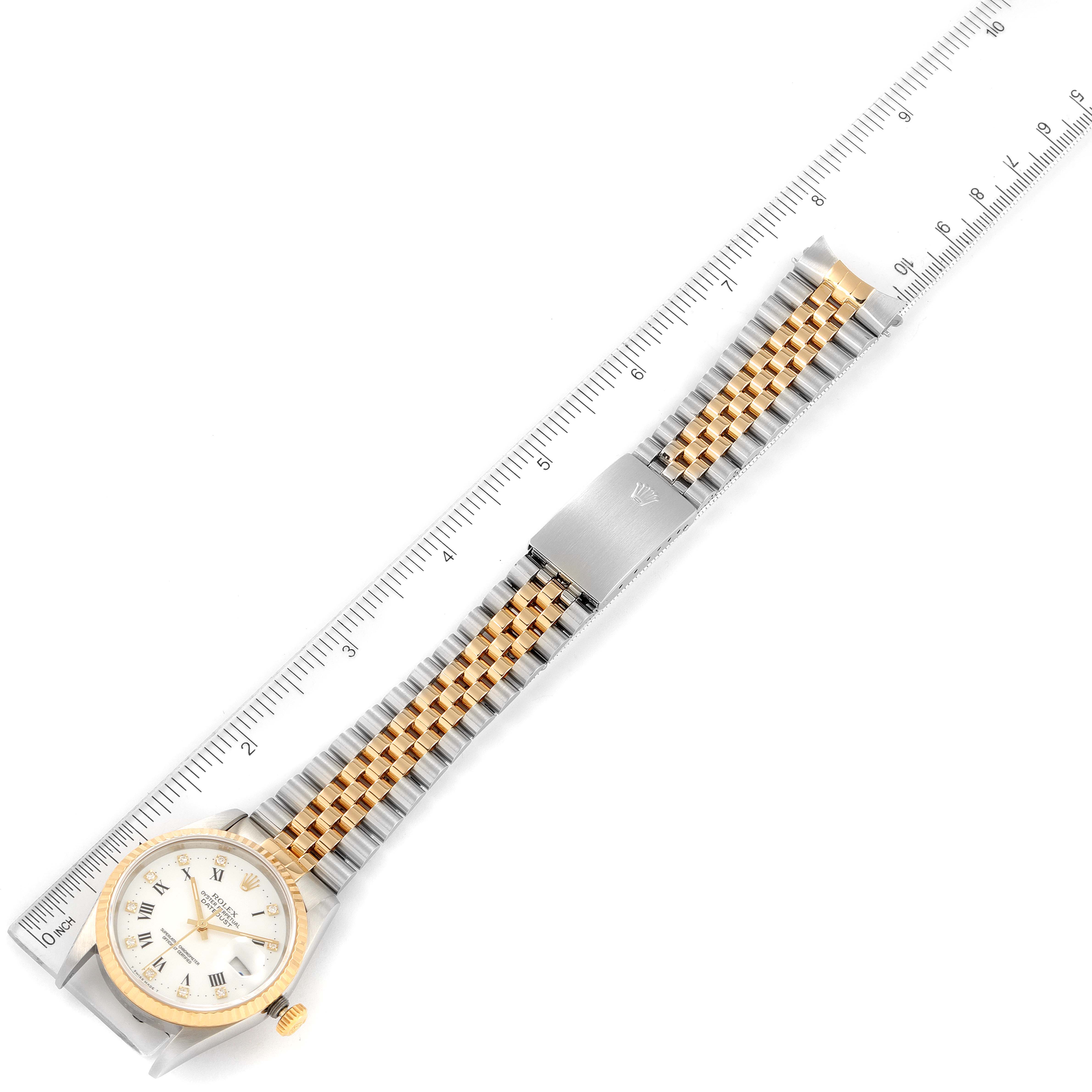 The image shows a top view of a Rolex Datejust 16233 Men's Steel and Gold (two tone) White Dial 16233 Men's Steel and Gold (two tone) White Dial watch with a two-tone bracelet, aligned next to a ruler.