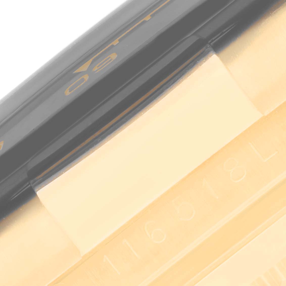 This close-up image shows the serial number and part of the bezel of a Rolex Daytona 116518 Men's Yellow Gold Mother of Pearl Dial 116518 Men's Yellow Gold Mother of Pearl Dial watch.