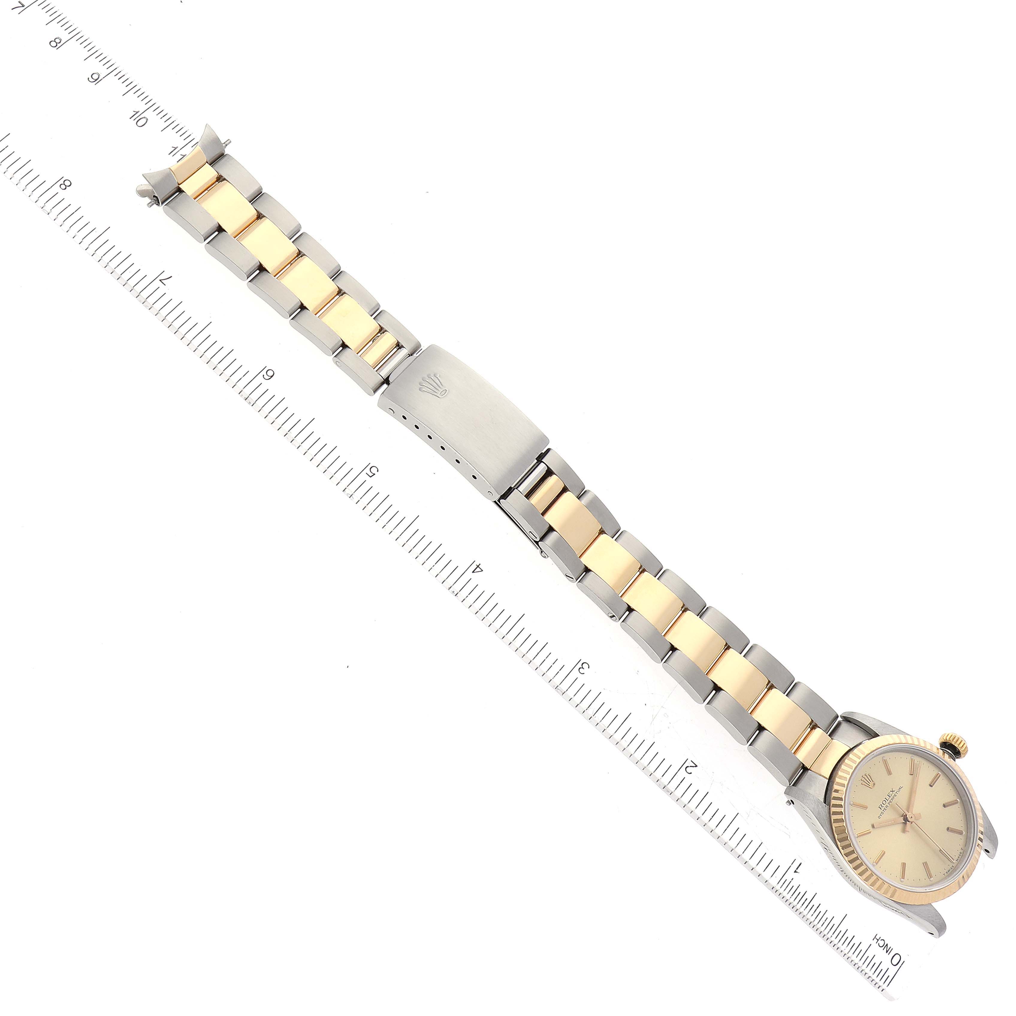 The image shows a Rolex Mid-Size 67513 Women's Steel and Gold (two tone) Champagne Dial 67513 Women's Steel and Gold (two tone) Champagne Dial watch from a top-down angle, featuring its face, bracelet, and clasp.