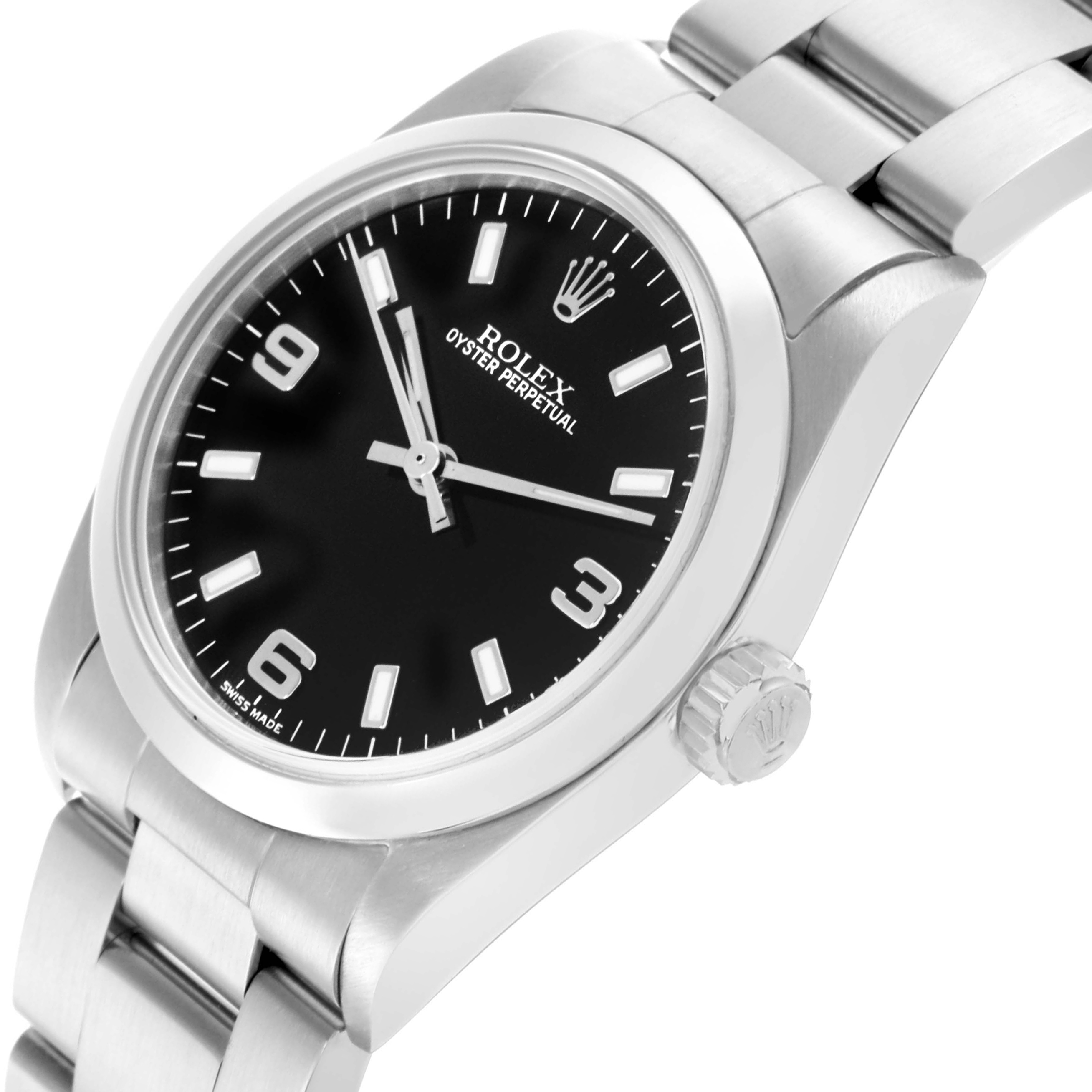 The Rolex Mid-Size 77080 Women's Stainless Steel Black Dial 77080 Women's Stainless Steel Black Dial Oyster Perpetual watch is shown at an angled view highlighting the black dial, bezel, bracelet, and crown.