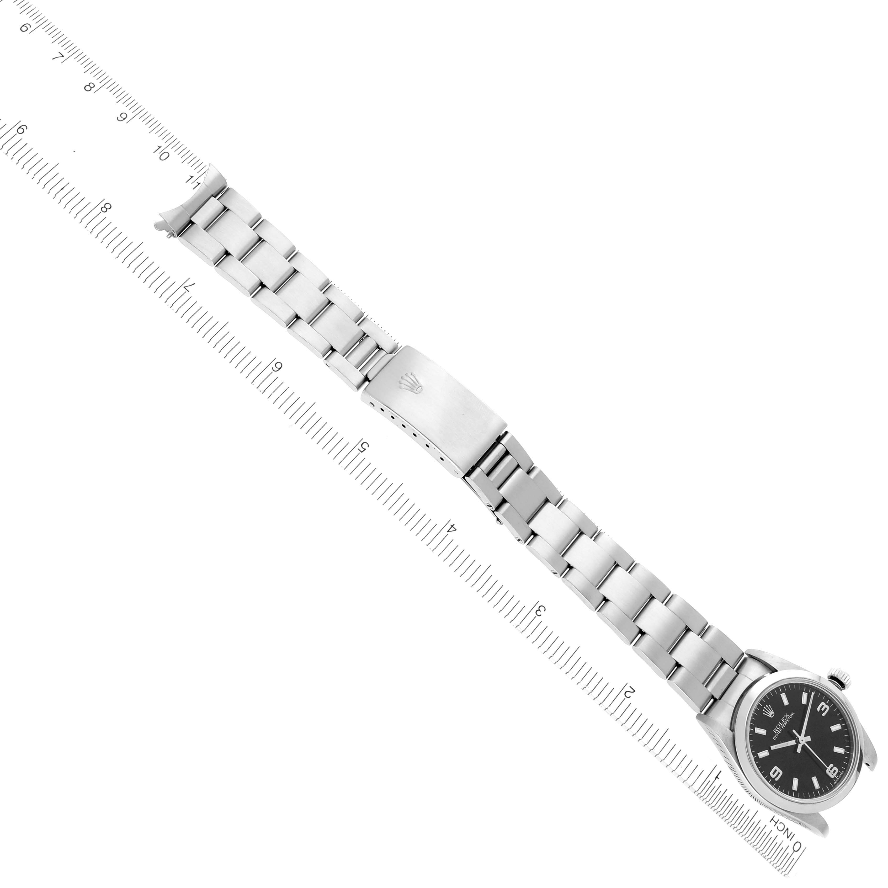 The image shows a mid-size Rolex watch fully extended alongside a ruler, showcasing the band and clasp.