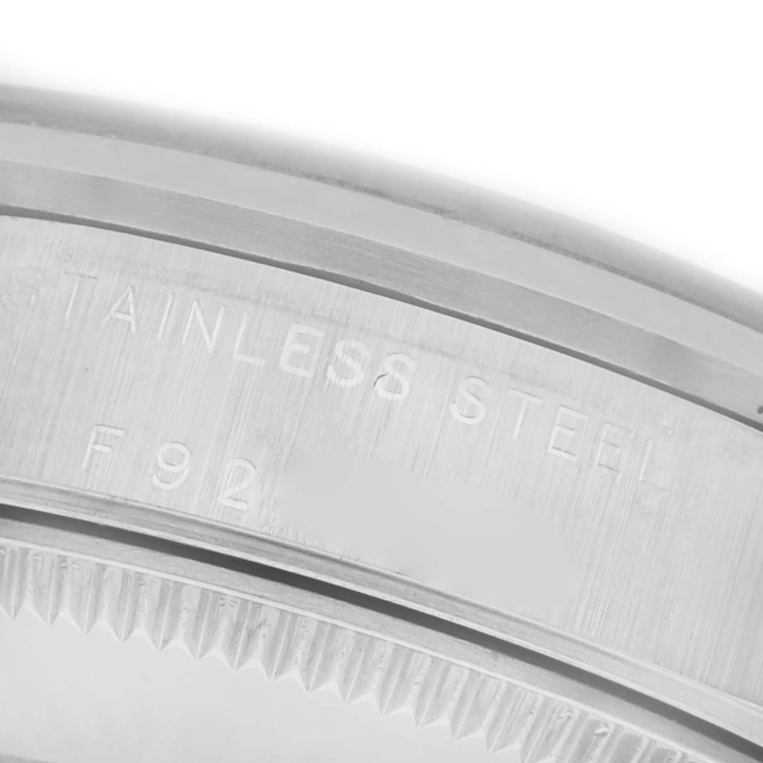 The image shows a close-up of the stainless steel bezel and rim detailing on a Mid-Size Rolex watch.