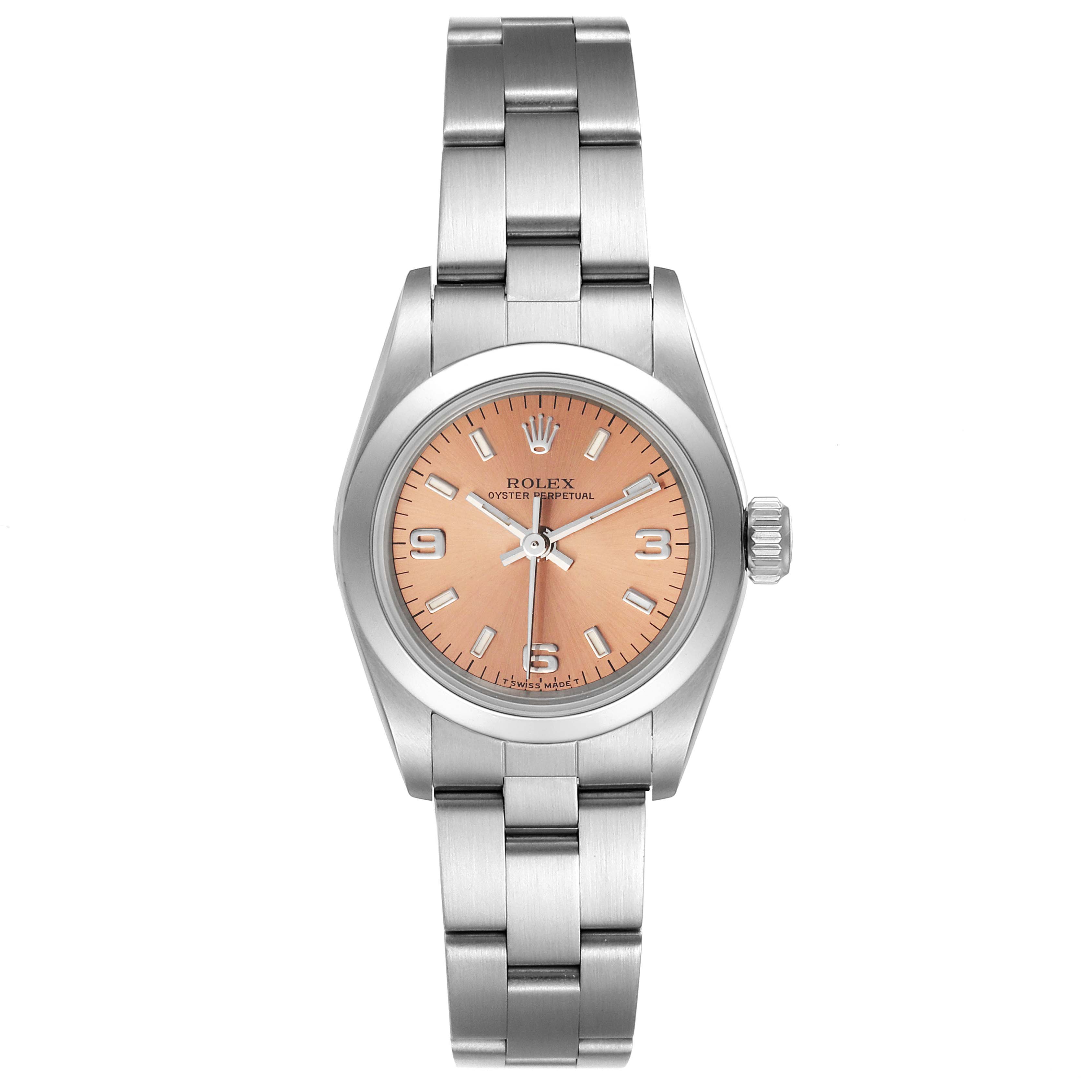 The image shows a front view of a Rolex Oyster Perpetual 67180 Women
s Stainless Steel Pink Dial 67180 Women
s Stainless Steel Pink Dial watch with a silver bracelet and a peach dial.