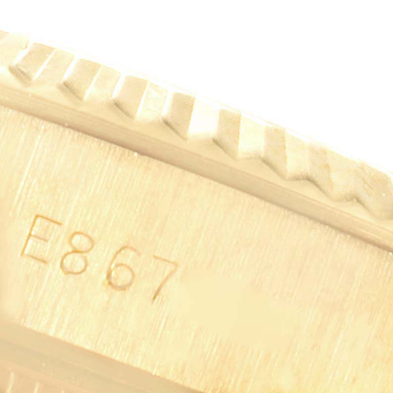 This image shows a close-up of the Rolex President 69178 Women
s Yellow Gold Champagne Dial 69178 Women
s Yellow Gold Champagne Dial model
s case edge and bezel, highlighting the fine detailing and engraved serial number.