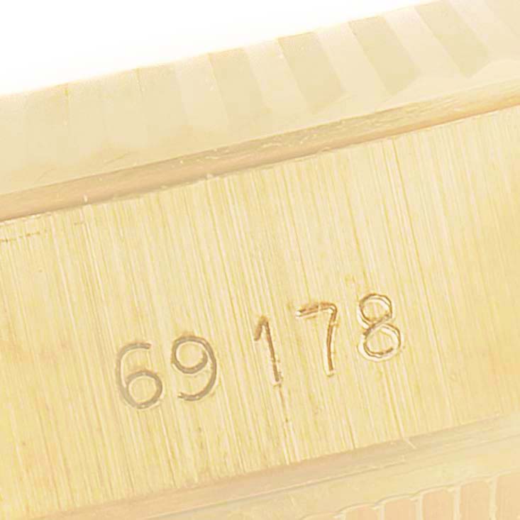 This close-up image shows the side of a Rolex President 69178 Women
s Yellow Gold Champagne Dial 69178 Women
s Yellow Gold Champagne Dial model watch, highlighting its engraved model number "69178" and fluted bezel.