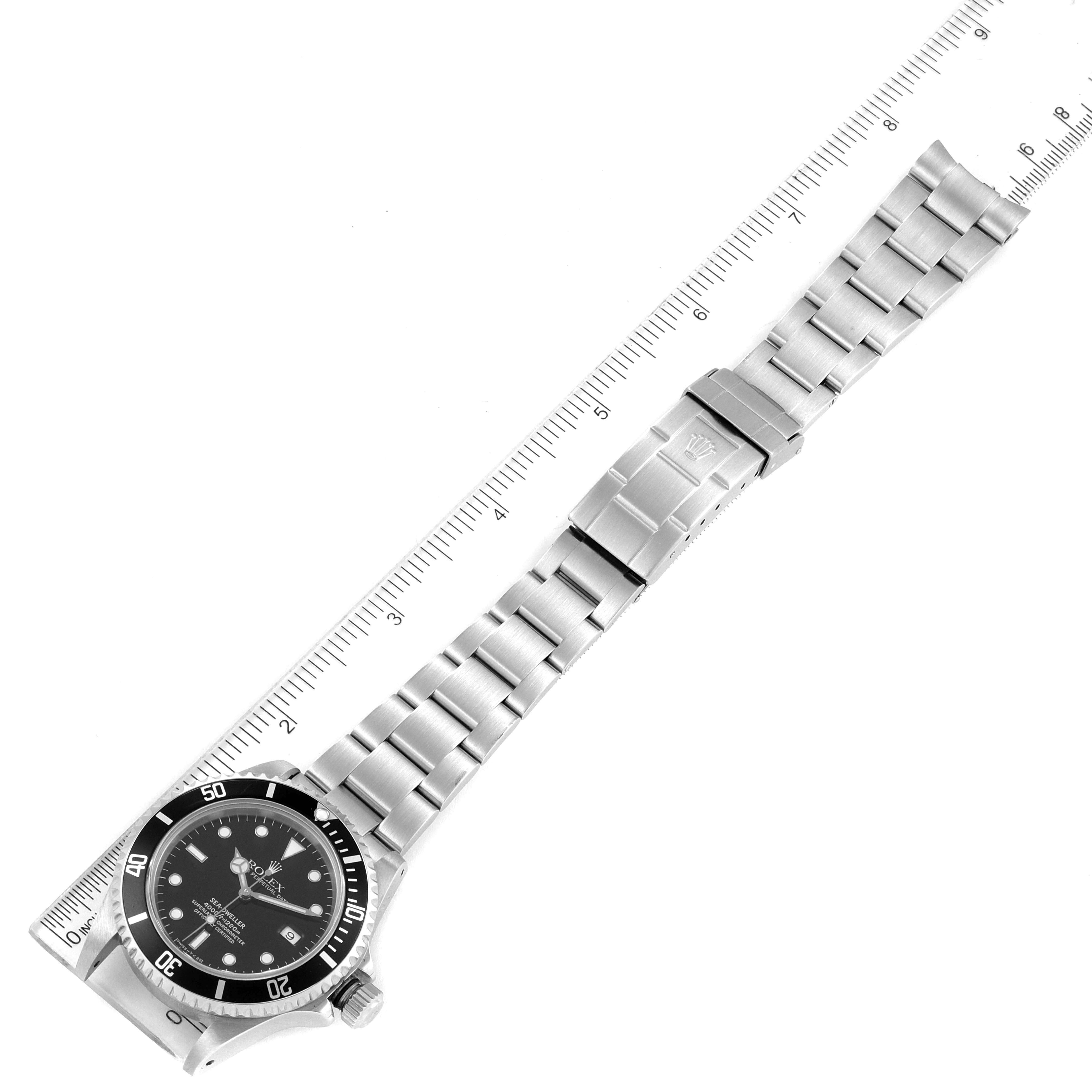 This image shows a top-down view of a Rolex Sea-Dweller 16600 Men
s Stainless Steel Black Dial 16600 Men
s Stainless Steel Black Dial watch, highlighting the bezel, dial, bracelet, and clasp alongside a ruler.