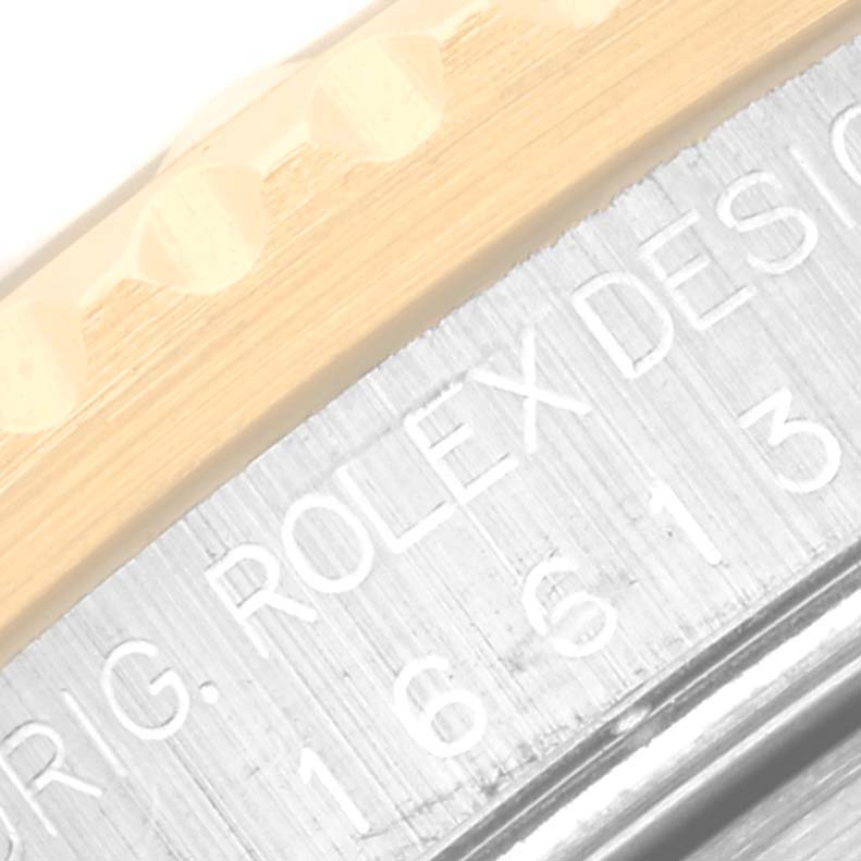 The image shows a close-up angle of the bezel and engraved case edge of a Rolex Submariner 16613 Men
s Steel and Gold (two tone) Blue Dial 16613 Men
s Steel and Gold (two tone) Blue Dial watch.