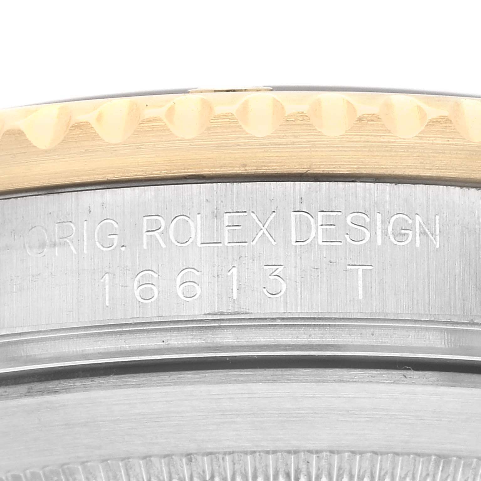 Close-up of a Rolex Submariner 16613 Men
s Steel and Gold (two tone) Grey Dial 16613 Men
s Steel and Gold (two tone) Grey Dial
s case, displaying the engraved model number "16613 T" and "Orig. Rolex Design."