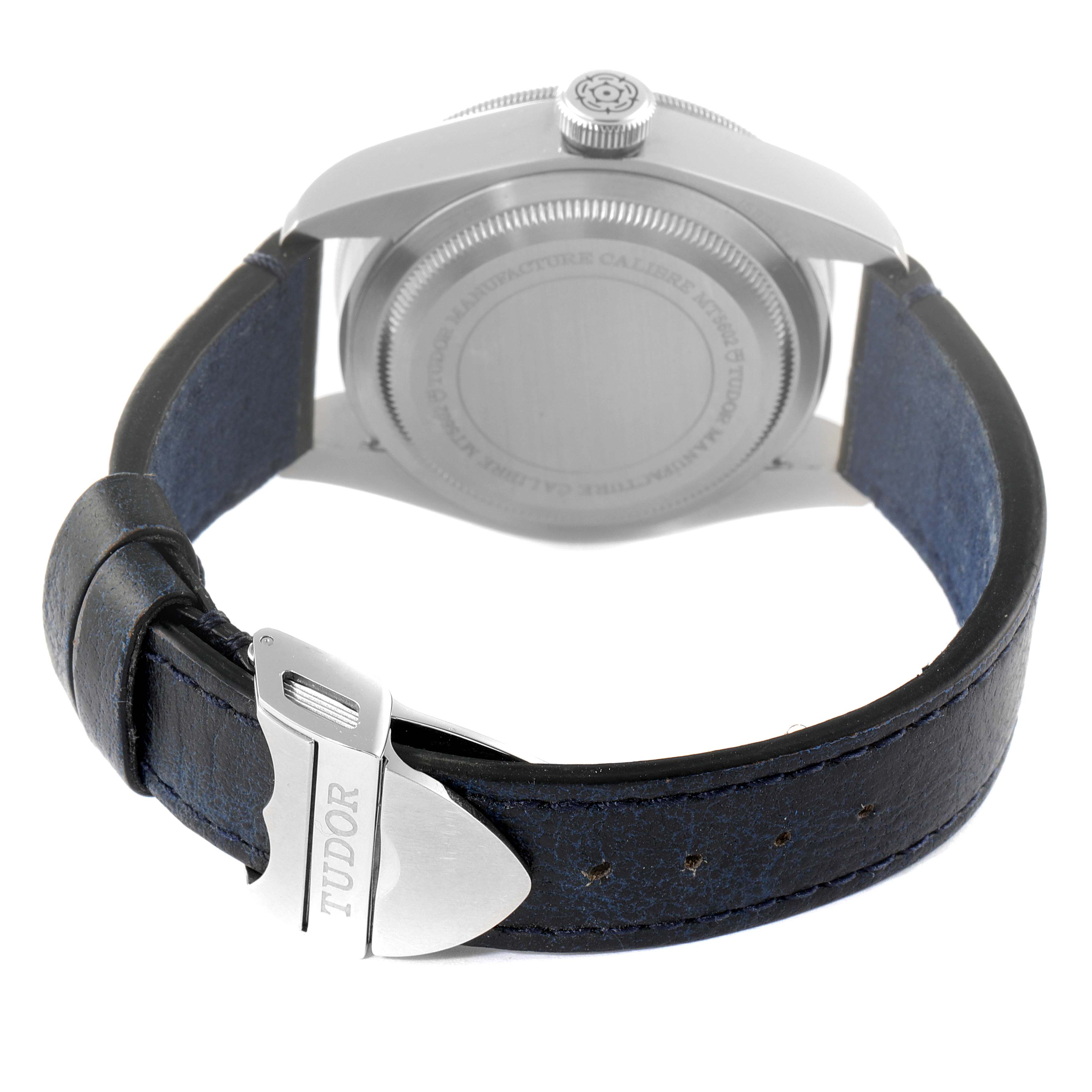 The image shows the back view of a Tudor Heritage Black Bay 79230B Men's Stainless Steel Black Dial 79230B Men's Stainless Steel Black Dial watch, highlighting its case back and leather strap with a metal clasp.