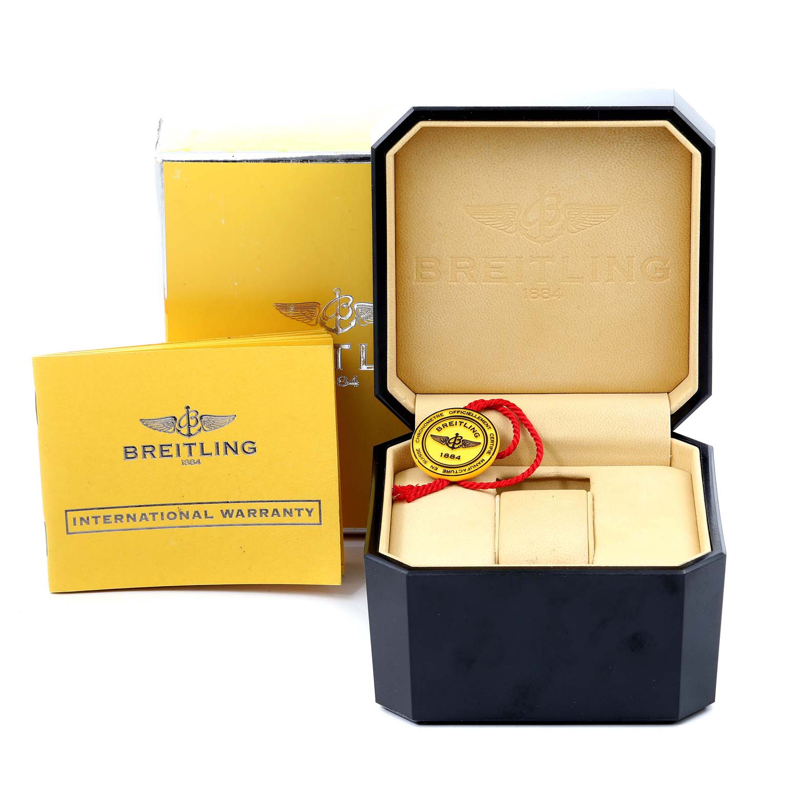 The image shows an empty Breitling Superocean A13340 Men's Stainless Steel Beige Dial A13340 Men's Stainless Steel Beige Dial watch box, an international warranty booklet, and a yellow tag with a red string.
