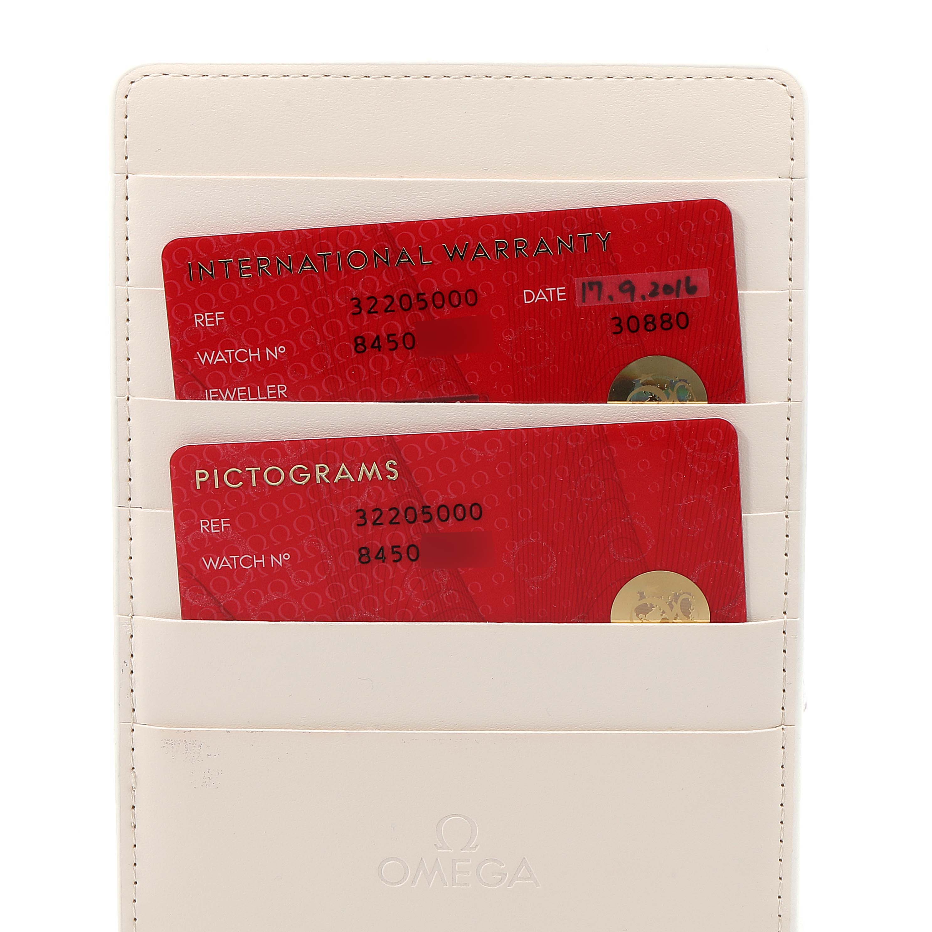 The image shows two Omega Speedmaster 3220.50.00 Men
s Stainless Steel Black Dial 3220.50.00 Men
s Stainless Steel Black Dial watch cards: an International Warranty card and a Pictograms card, placed in a white cardholder.