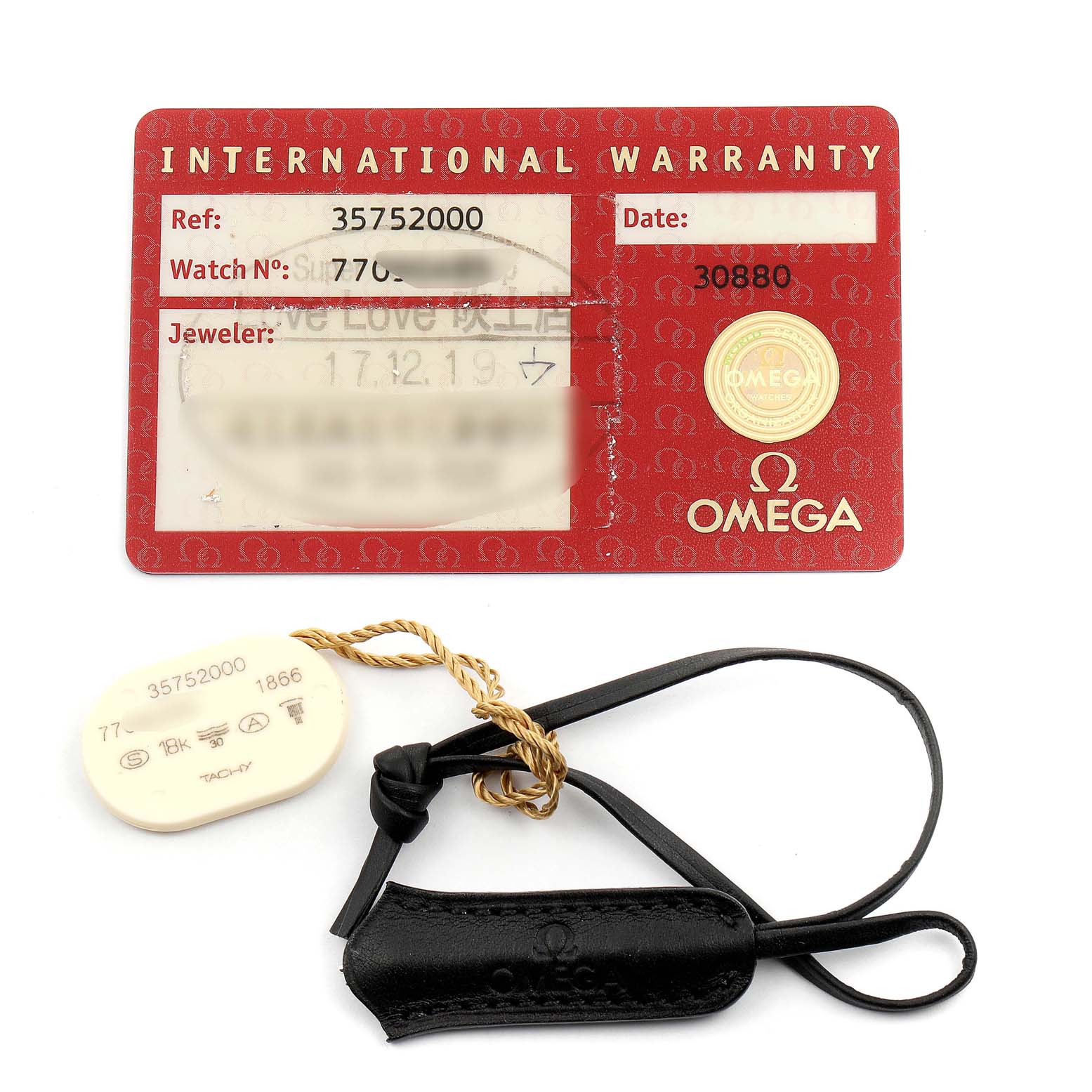 This image shows an Omega Speedmaster 3575.20.00 Men's Stainless Steel White Dial 3575.20.00 Men's Stainless Steel White Dial warranty card, hang tag, and a watch holder strap.