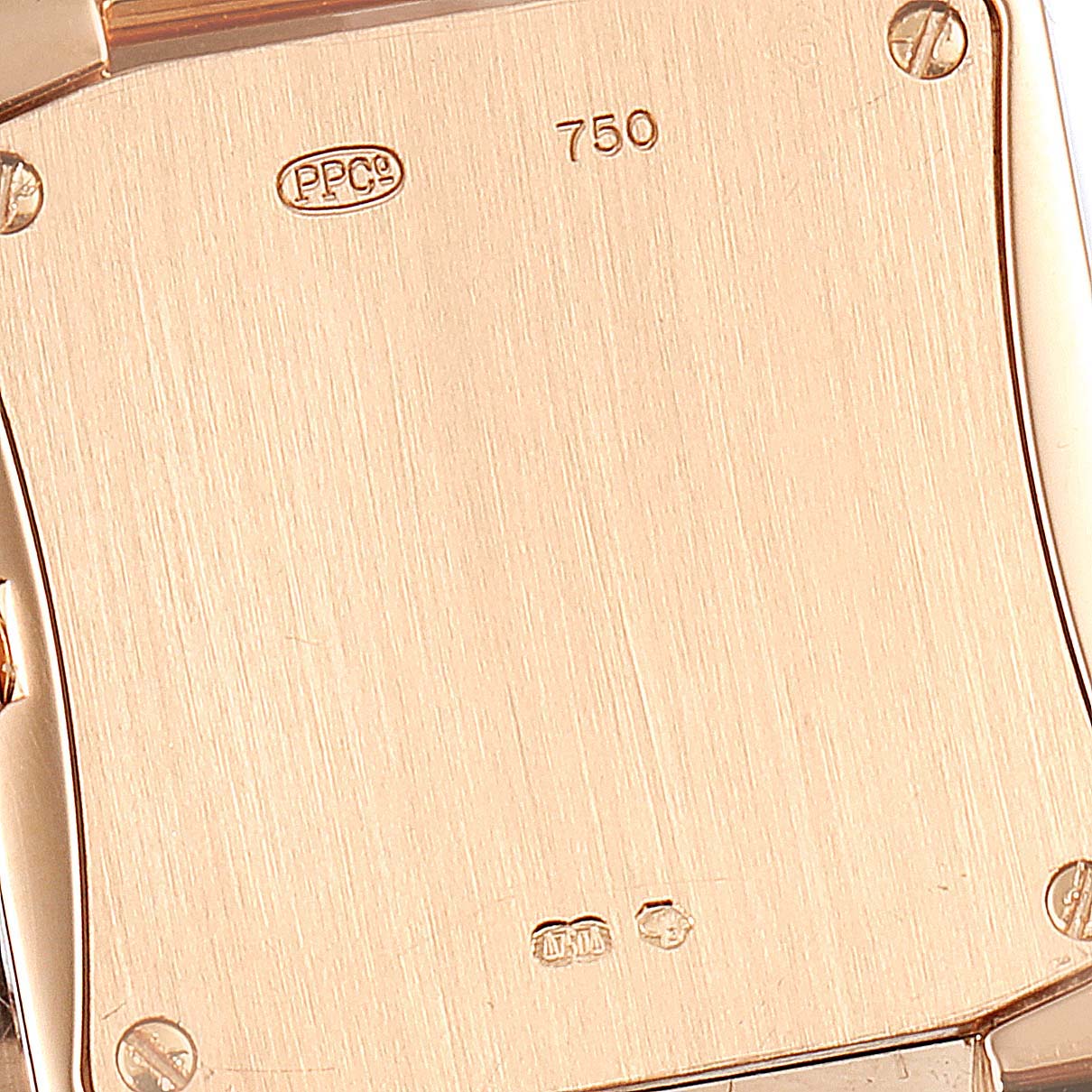This is a close-up image of the back case of a Patek Philippe Twenty-4 4908/11R Women's Rose Gold Brown Dial 4908/11R Women's Rose Gold Brown Dial model watch, showing hallmark engravings and screws.