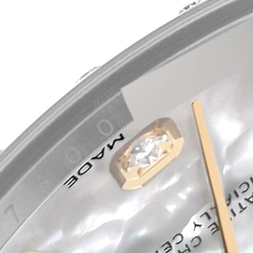 A close-up of the Rolex Mid-Size 178343 Women
s Steel and Gold (two tone) Mother of Pearl Dial 178343 Women
s Steel and Gold (two tone) Mother of Pearl Dial model shows the "Made" lettering, part of the dial, and a diamond-set hour marker.