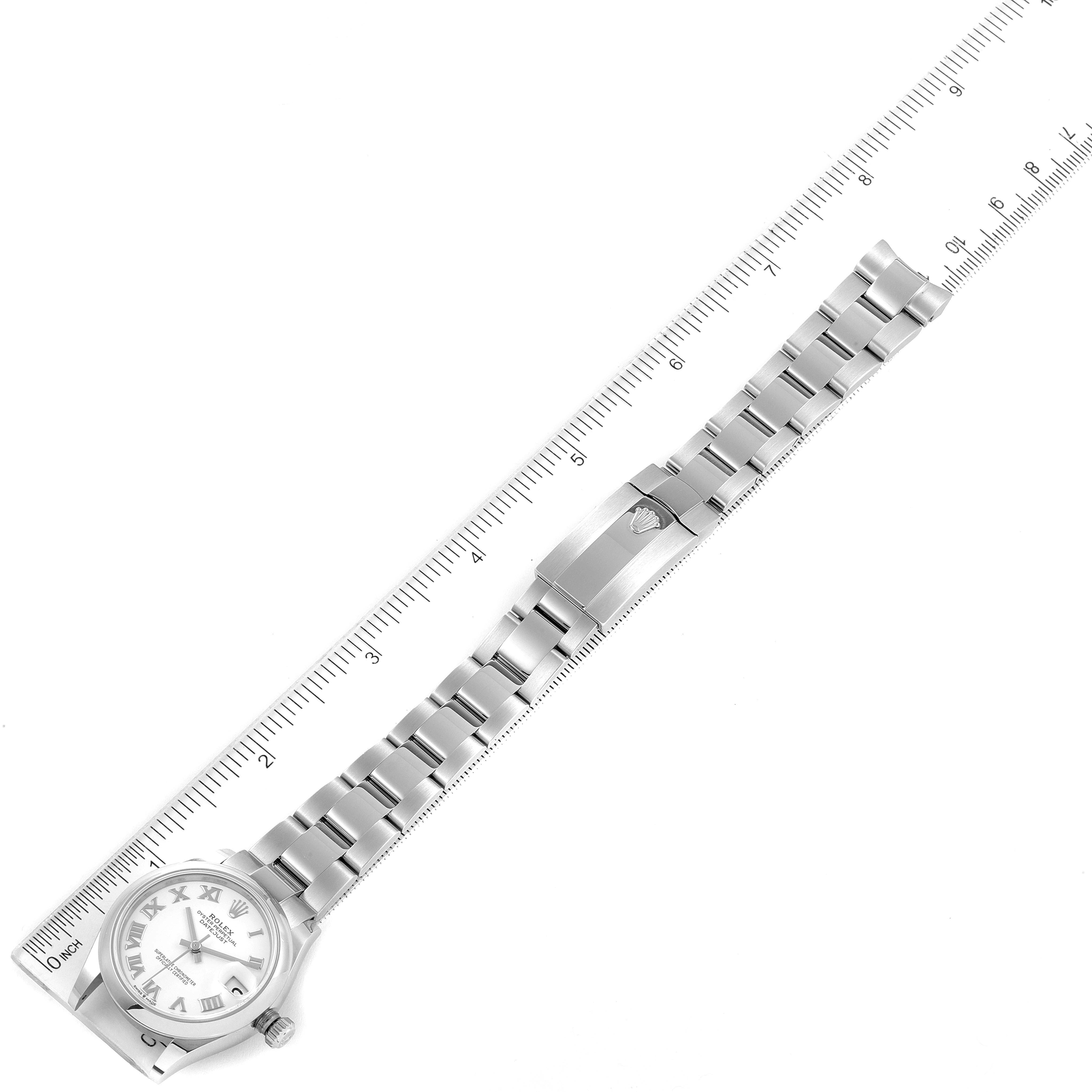 The image shows a Mid-Size Rolex watch laid flat, with its face, bracelet, and clasp visible on a ruler for size reference.