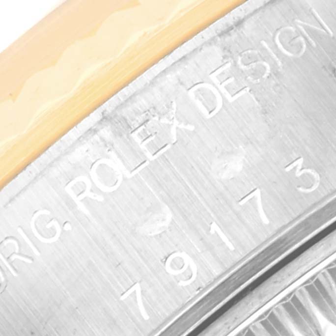Close-up of the side of a Rolex Datejust 79173 Women's Steel and Gold (two tone) Champagne Dial 79173 Women's Steel and Gold (two tone) Champagne Dial watch showing the engraved "ROLEX DESIGN 79173".