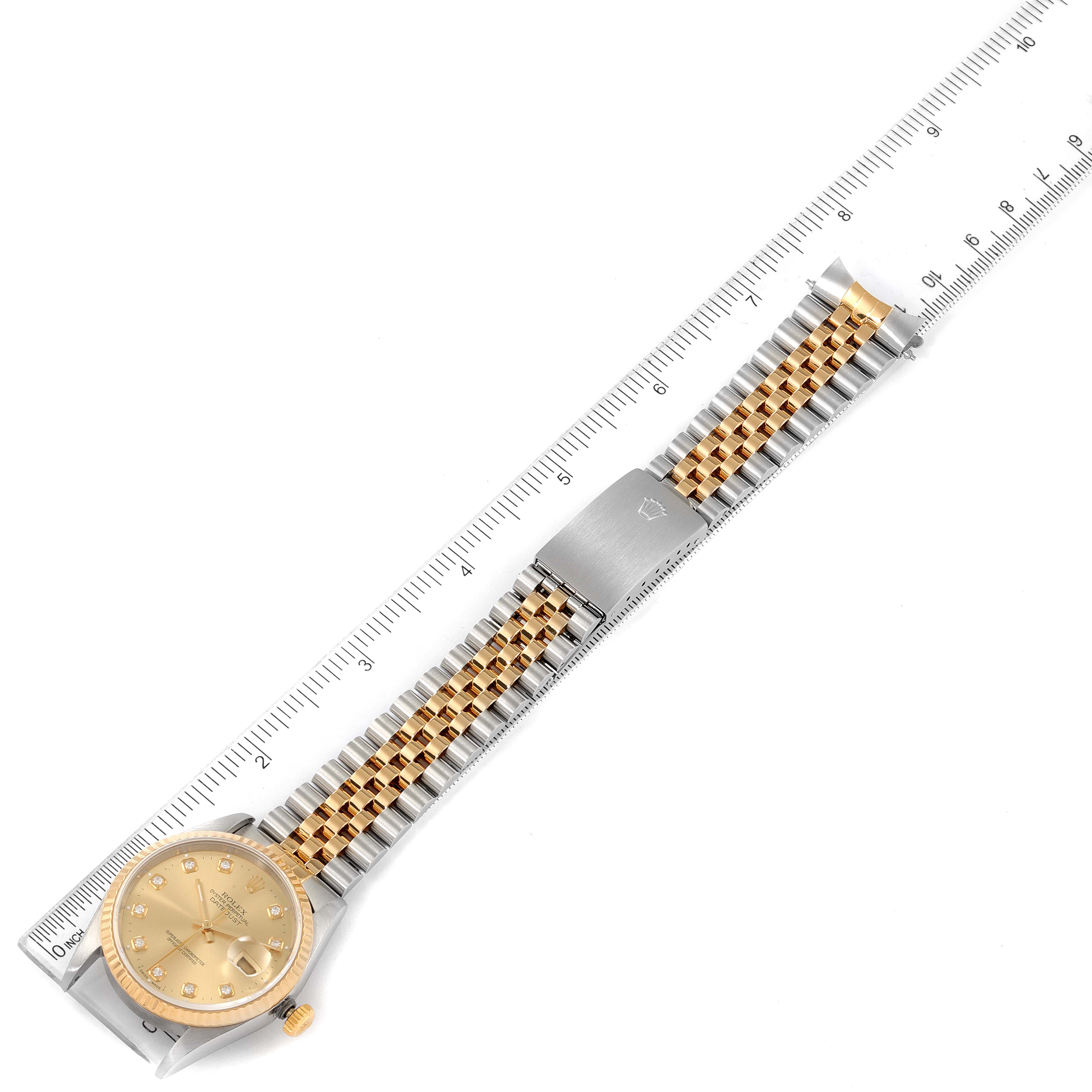 The Rolex Datejust 16233 Men's Steel and Gold (two tone) Champagne Dial 16233 Men's Steel and Gold (two tone) Champagne Dial watch is shown from a top-down angle, highlighting the full bracelet, clasp, and dial, with a ruler beside it for scale.