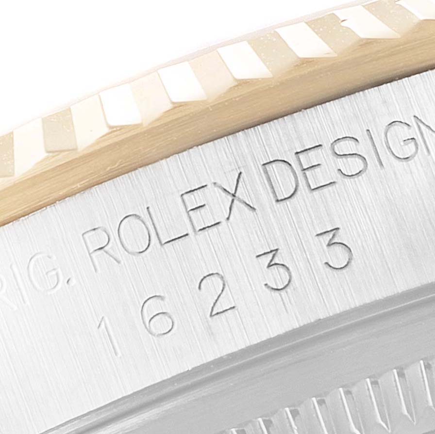 This close-up image shows the engraved model number and fluted bezel of a Rolex Datejust 16233 Men's Steel and Gold (two tone) Champagne Dial 16233 Men's Steel and Gold (two tone) Champagne Dial watch.