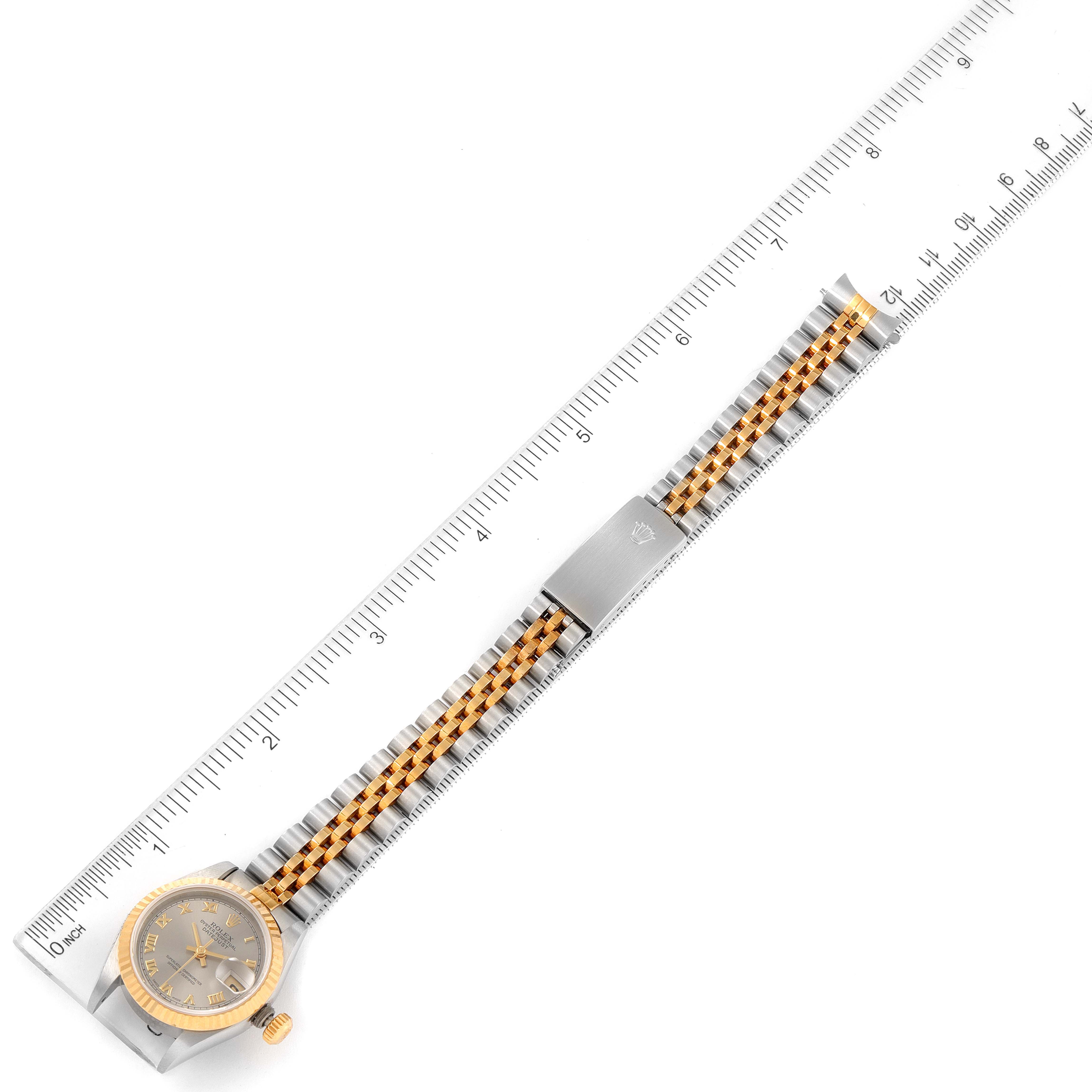 The image shows a top-down view of a Rolex Datejust 69173 Women's Steel and Gold (two tone) Grey Dial 69173 Women's Steel and Gold (two tone) Grey Dial watch, focusing on its face and metal bracelet alongside a ruler for scale.