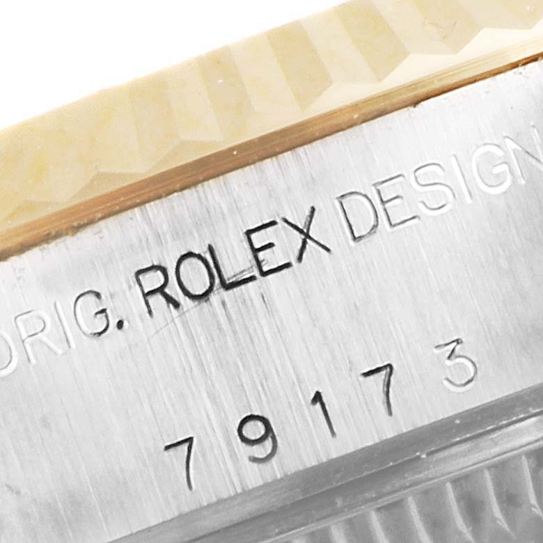 This close-up image shows the engraved serial number and part of the bezel on a Rolex Datejust 79173 Women's Steel and Gold (two tone) White Dial 79173 Women's Steel and Gold (two tone) White Dial watch.