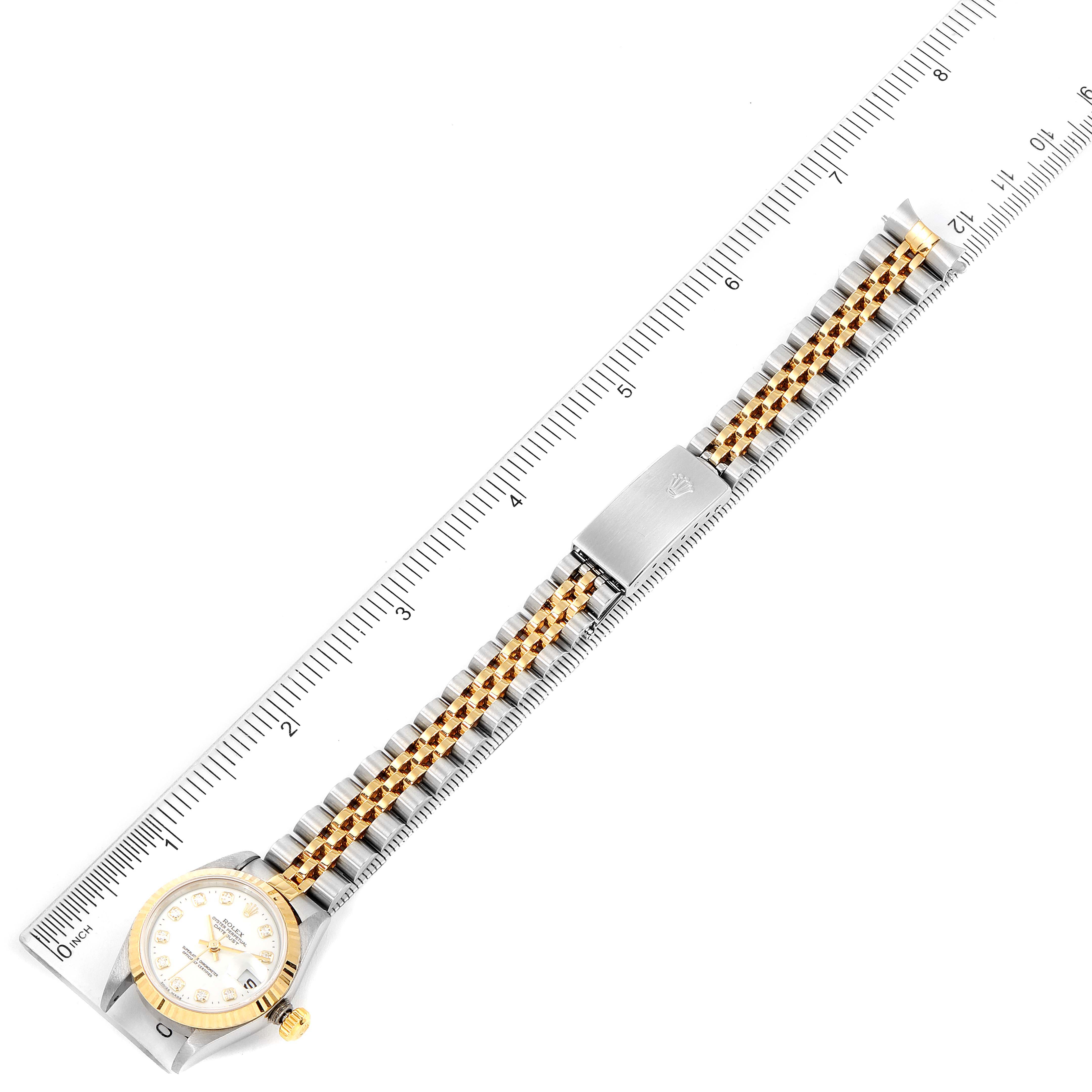 The image shows a top-down view of a Rolex Datejust 79173 Women's Steel and Gold (two tone) White Dial 79173 Women's Steel and Gold (two tone) White Dial watch with its full bracelet laid against a ruler for measurement.