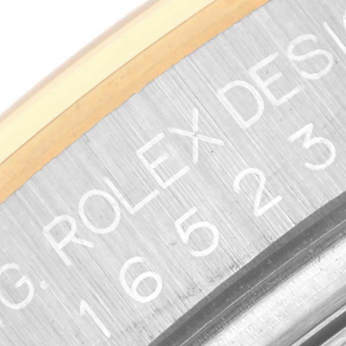 The image shows a close-up of the side engraving on a Rolex Daytona 16523 Men's Steel and Gold (two tone) Champagne Dial 16523 Men's Steel and Gold (two tone) Champagne Dial watch, displaying the Rolex branding and model number.