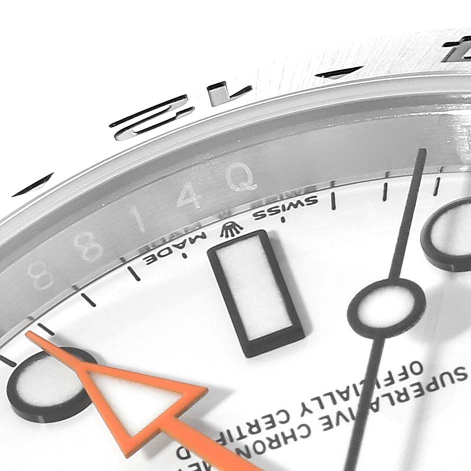 This close-up image of a Rolex Explorer 226570 Men
s Stainless Steel White Dial 226570 Men
s Stainless Steel White Dial model watch shows part of the dial, indices, and the orange hand.