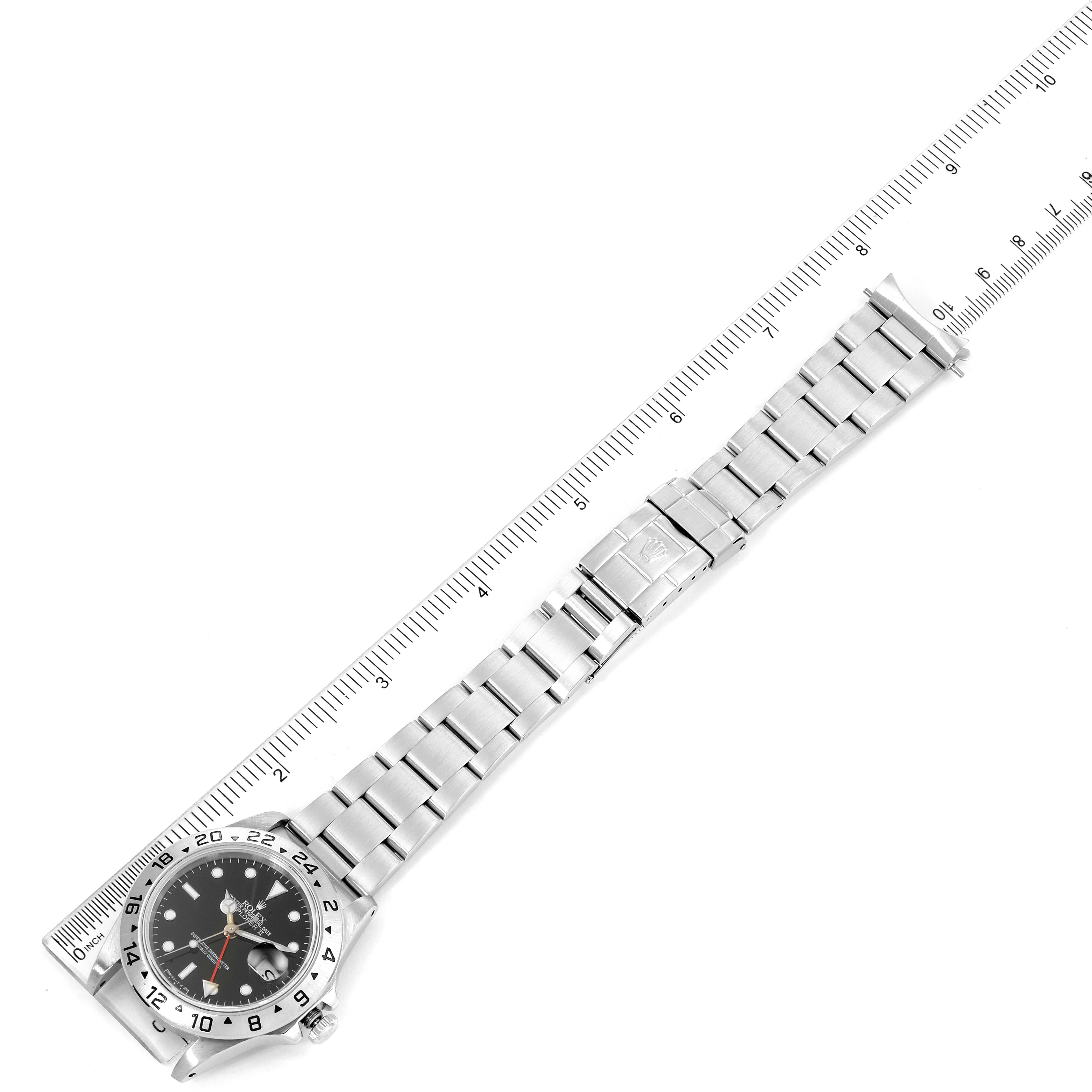 The image shows a Rolex Explorer 16570 Men
s Stainless Steel Black Dial 16570 Men
s Stainless Steel Black Dial watch laid flat with its bracelet extended and a ruler placed alongside for measurement.