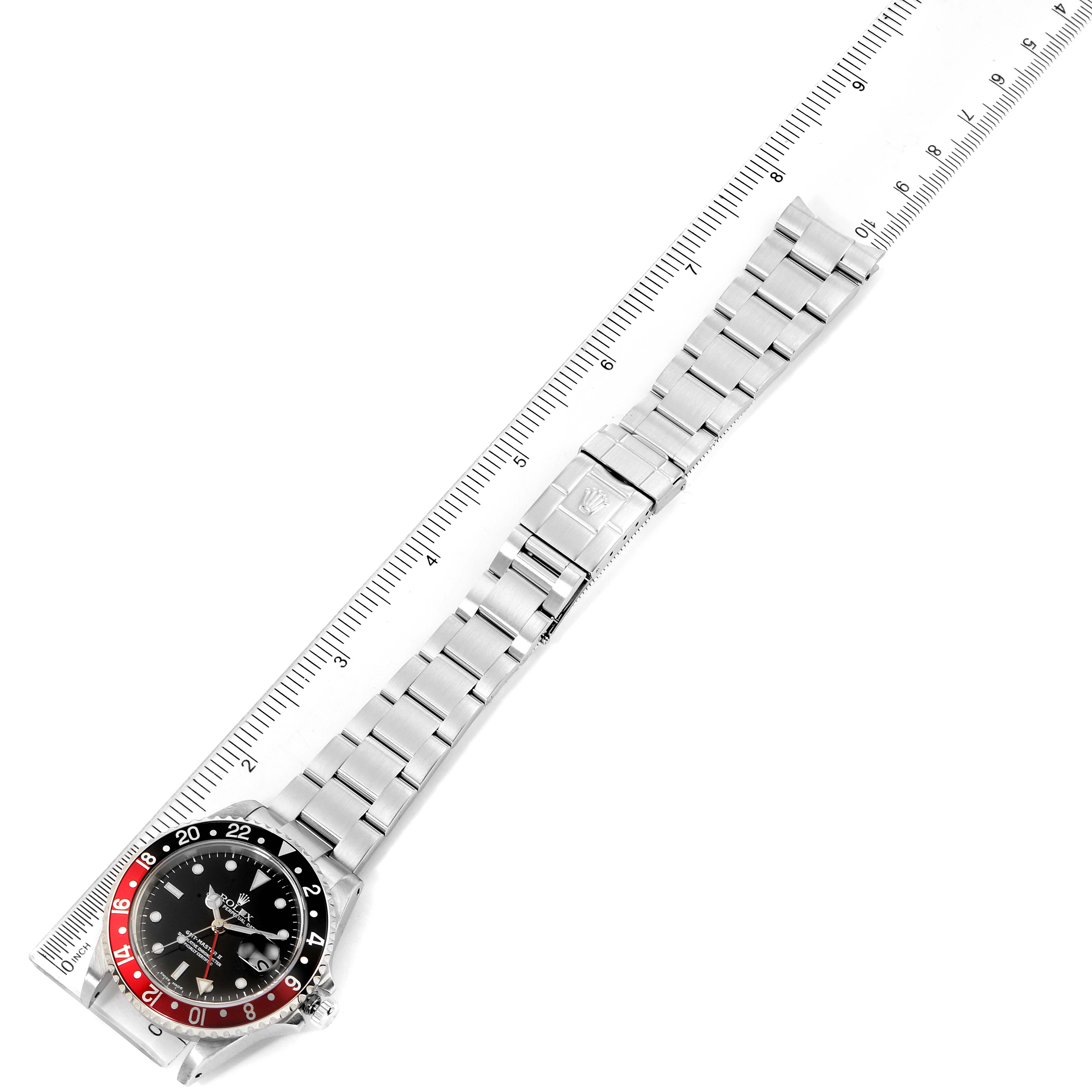 The image shows a Rolex GMT-Master 16710 Men's Stainless Steel Black Dial 16710 Men's Stainless Steel Black Dial watch laid flat next to a ruler, displaying its entire watchband and bezel.