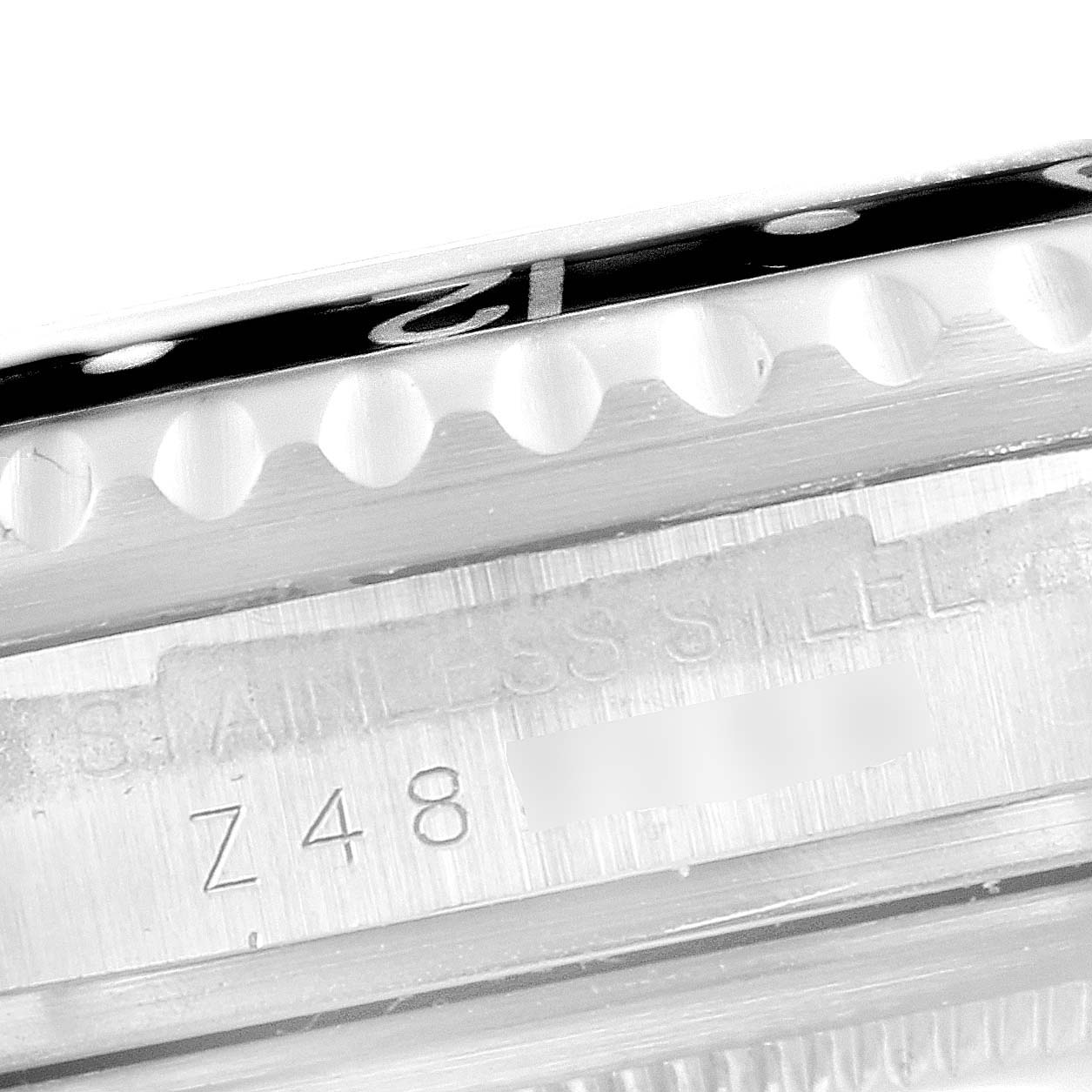 The image shows a close-up of the case side and bezel of a Rolex GMT-Master 16710 Men's Stainless Steel Black Dial 16710 Men's Stainless Steel Black Dial watch, highlighting the "STAINLESS STEEL" engraving and part of the serial number.