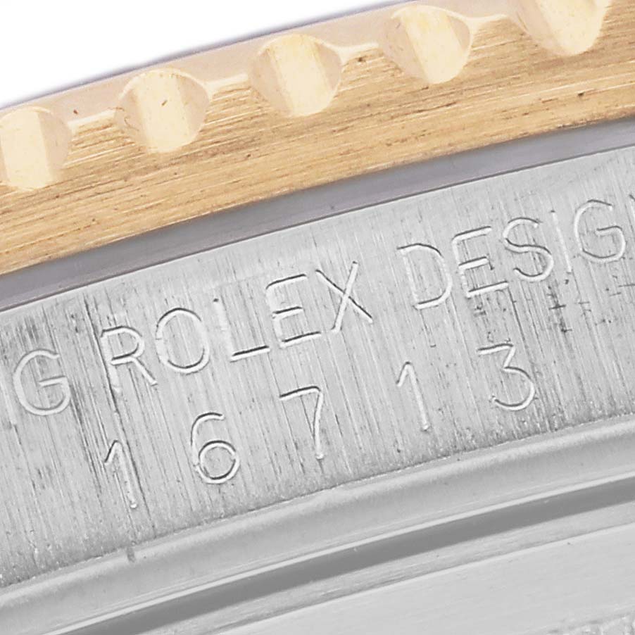 The image shows a close-up of the bezel and case edge with engraved text on a Rolex GMT-Master 16713 Men's Steel and Gold (two tone) Black Dial 16713 Men's Steel and Gold (two tone) Black Dial.