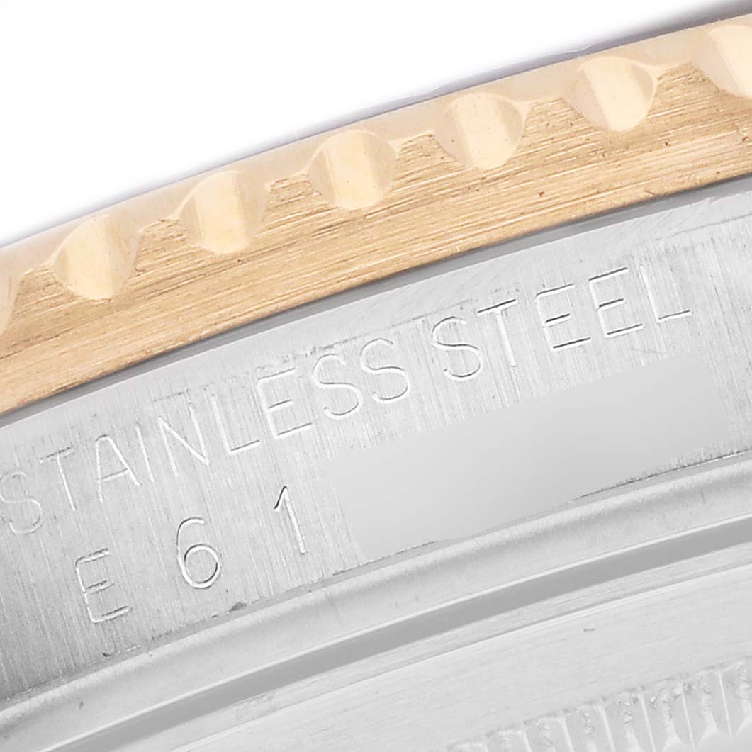 The image shows a close-up of the Rolex GMT-Master 16713 Men's Steel and Gold (two tone) Black Dial 16713 Men's Steel and Gold (two tone) Black Dial watch, focusing on the engraved stainless steel bezel and part of the case.