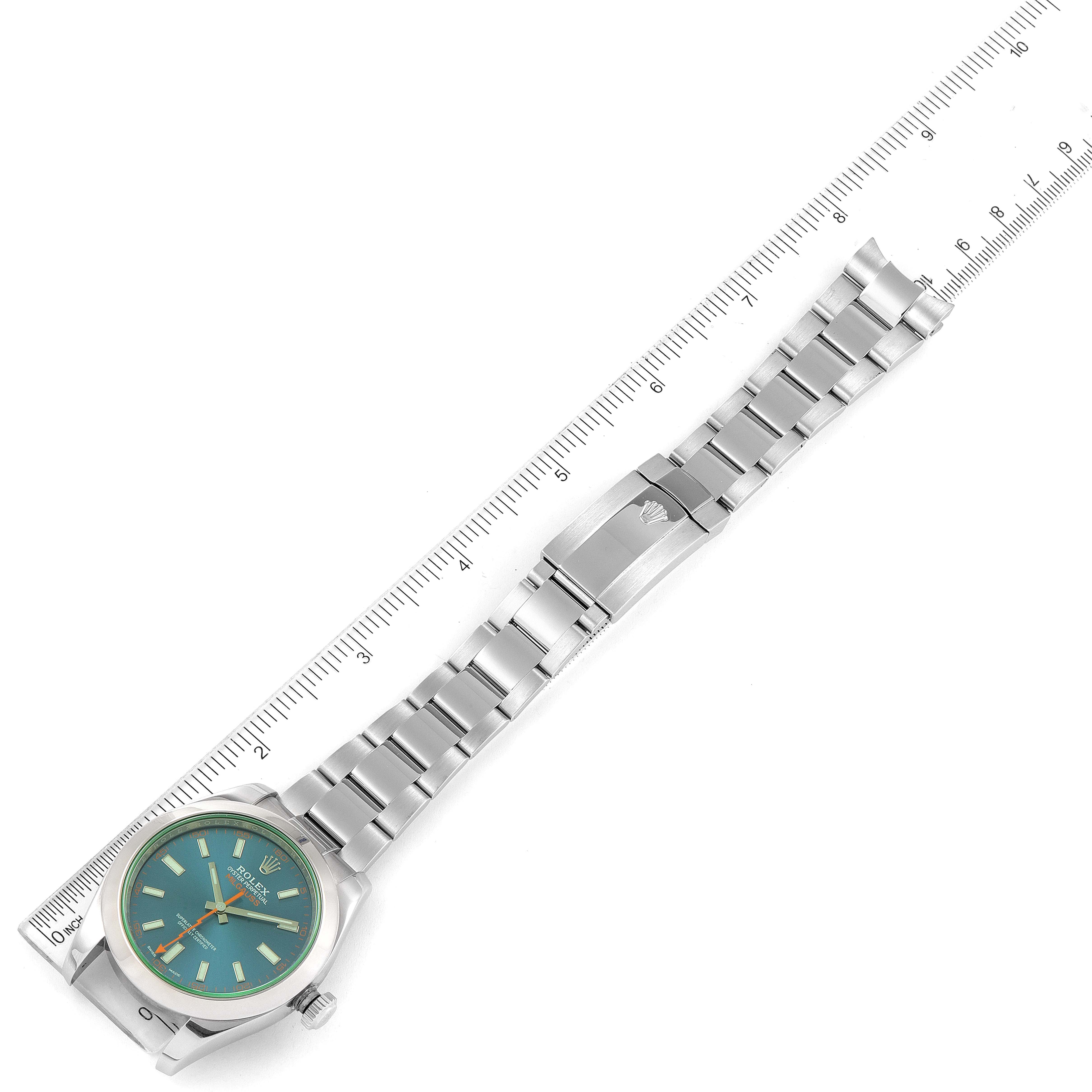 This image shows the Rolex Milgauss 116400GV Men's Stainless Steel Blue Dial 116400GV Men's Stainless Steel Blue Dial watch laid flat next to a ruler, displaying its face, bracelet, and clasp.