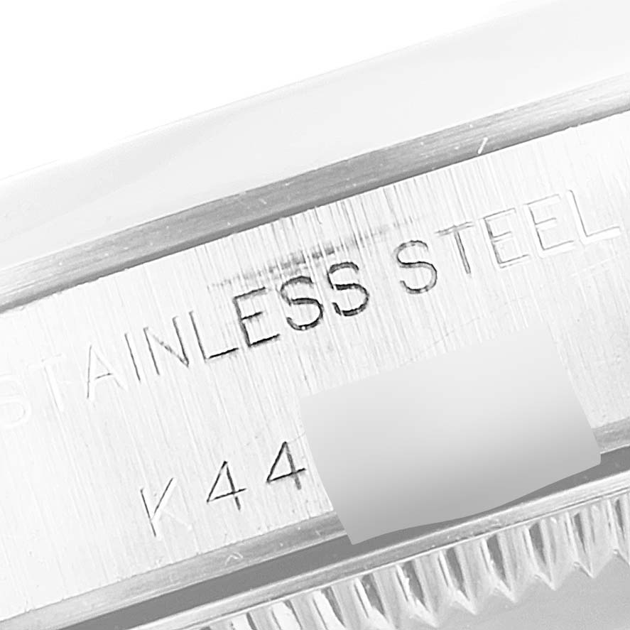 This image shows a close-up angle of the side of the Rolex Oyster Perpetual 76080 Women
s Stainless Steel Blue Dial 76080 Women
s Stainless Steel Blue Dial watch, focusing on the stainless steel engraving.