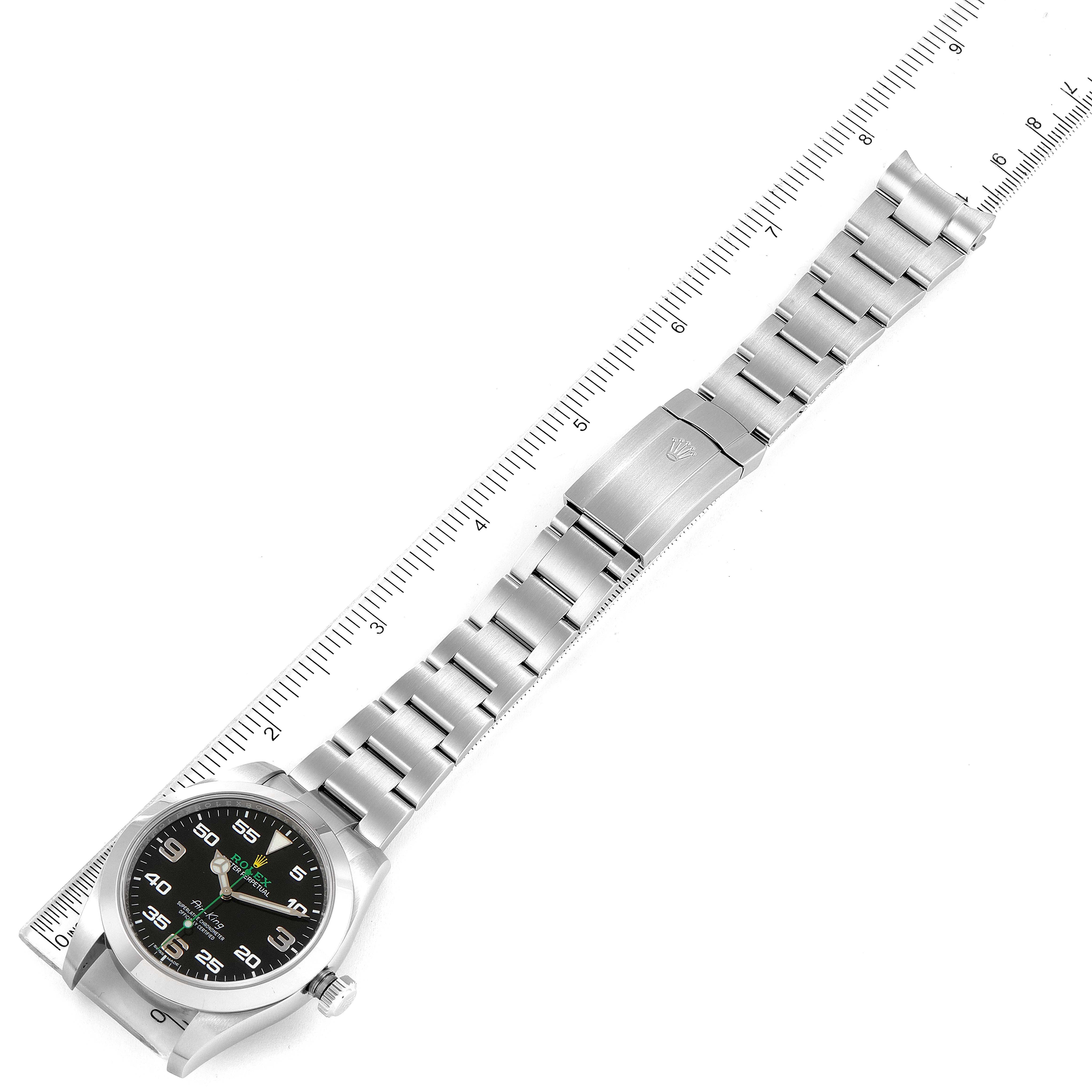 The image shows a top-down view of a Rolex Air-King 116900 Men's Stainless Steel Black Dial 116900 Men's Stainless Steel Black Dial watch, highlighting its stainless steel bracelet and black dial against a measuring ruler.