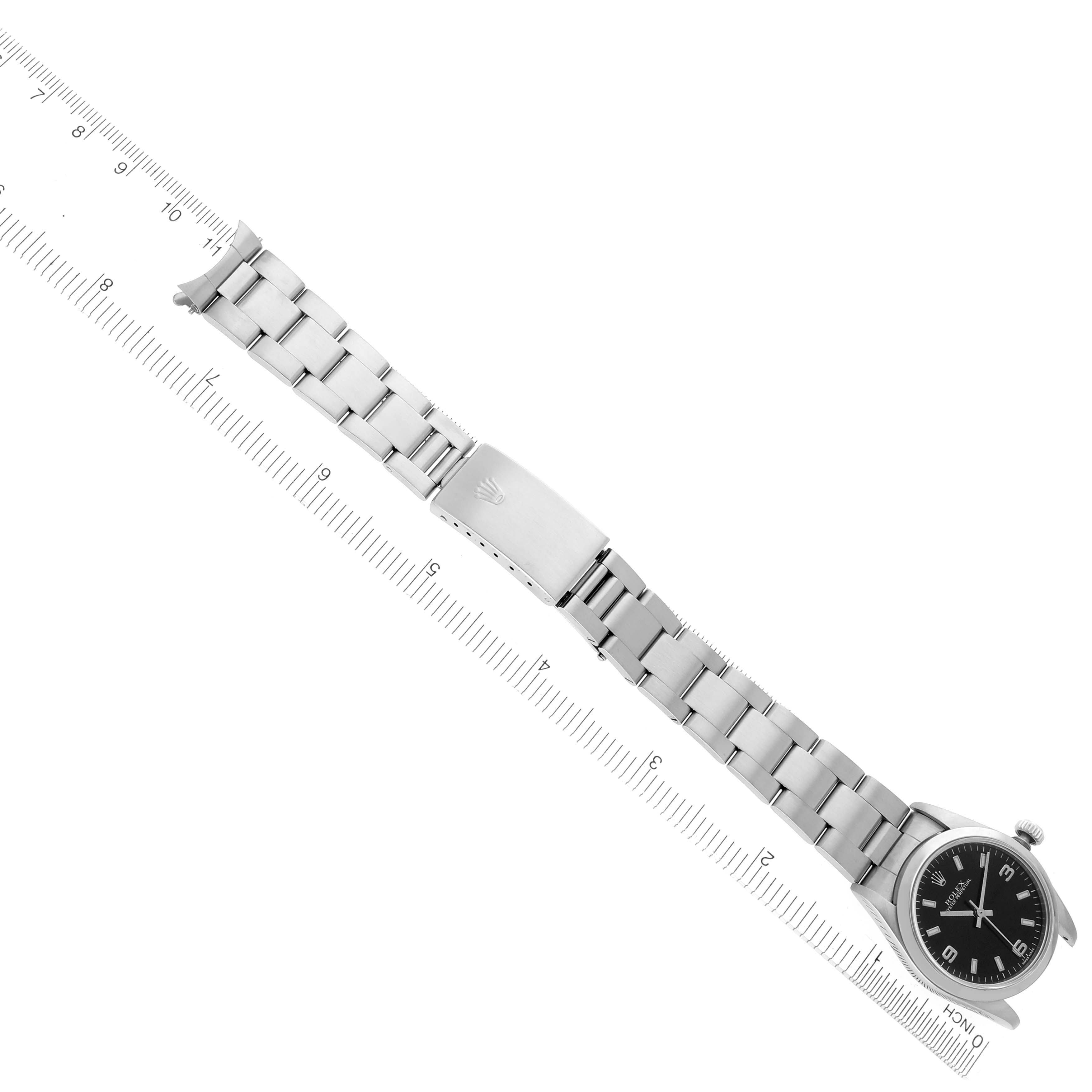 The Rolex Mid-Size 67480 Women's Stainless Steel Black Dial 67480 Women's Stainless Steel Black Dial model watch is shown from a top-down angle, displaying the entire bracelet and watch face alongside a ruler for scale.