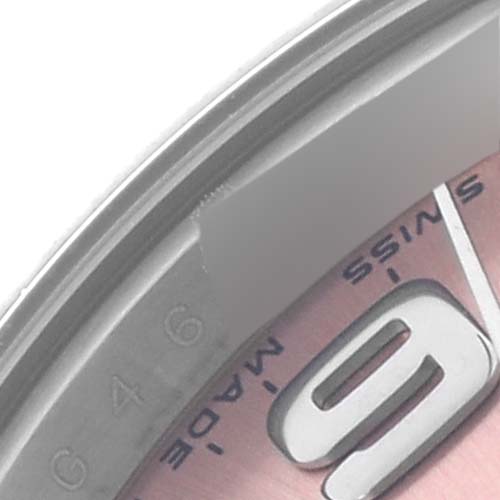 The image shows a close-up of the Rolex Oyster Perpetual 176200 Women's Stainless Steel Pink Dial 176200 Women's Stainless Steel Pink Dial watch's bezel, part of the dial, and a numeral at an angle.