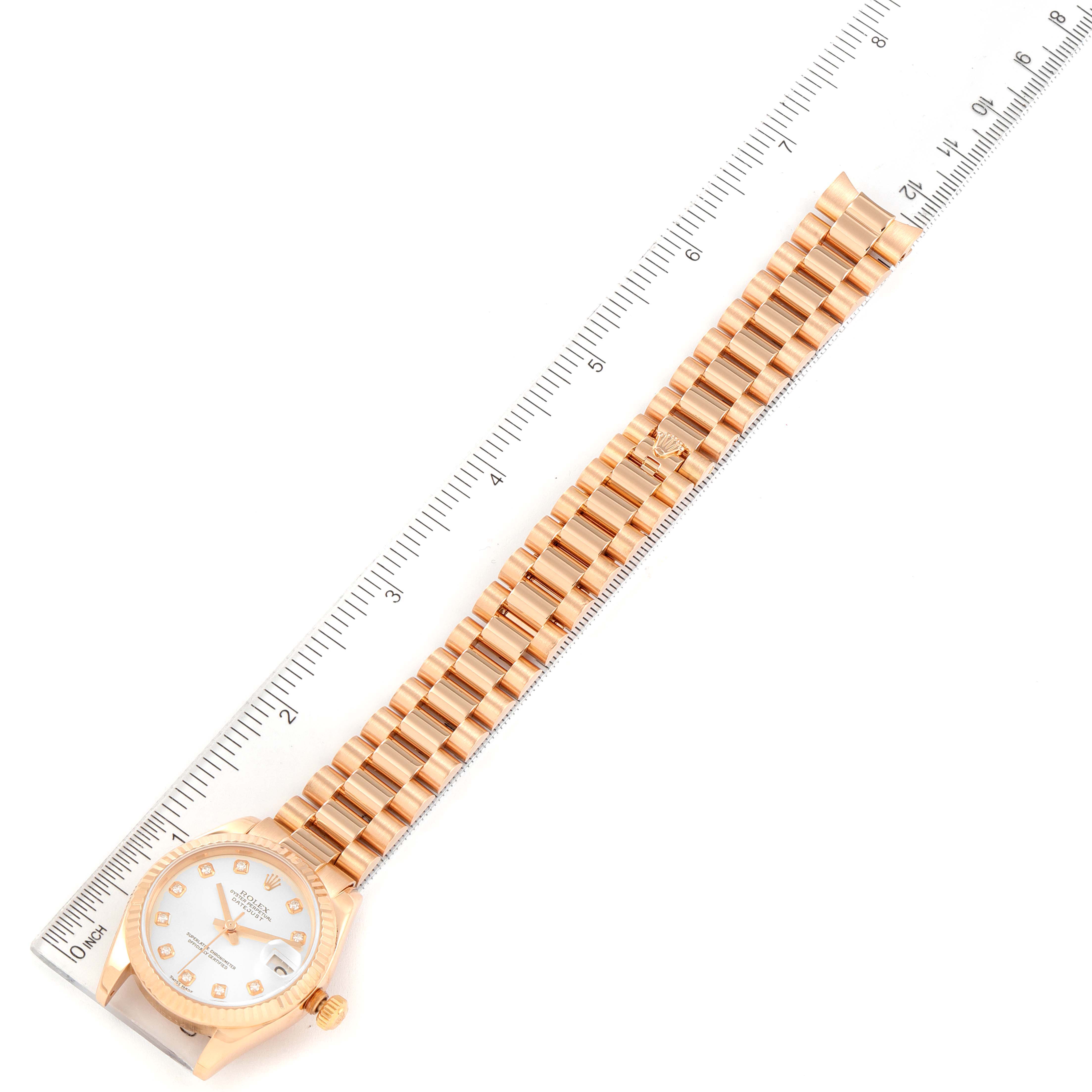 The image shows a top-down view of a Rolex President 178275 Women's Rose Gold Silver Dial 178275 Women's Rose Gold Silver Dial model watch with its bracelet fully extended next to a ruler.