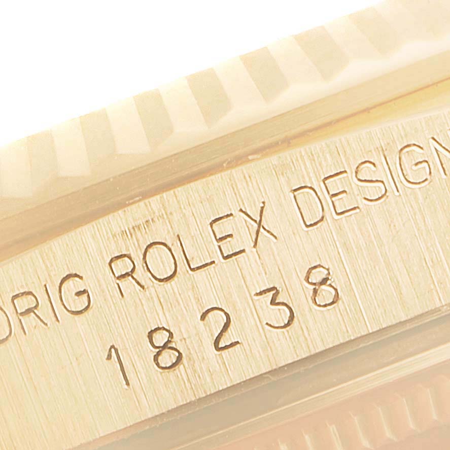 This close-up image shows part of the case with the engraving "ORIG ROLEX DESIGN 18238" of the Rolex President 18238 Men's Yellow Gold Champagne Dial 18238 Men's Yellow Gold Champagne Dial model watch.