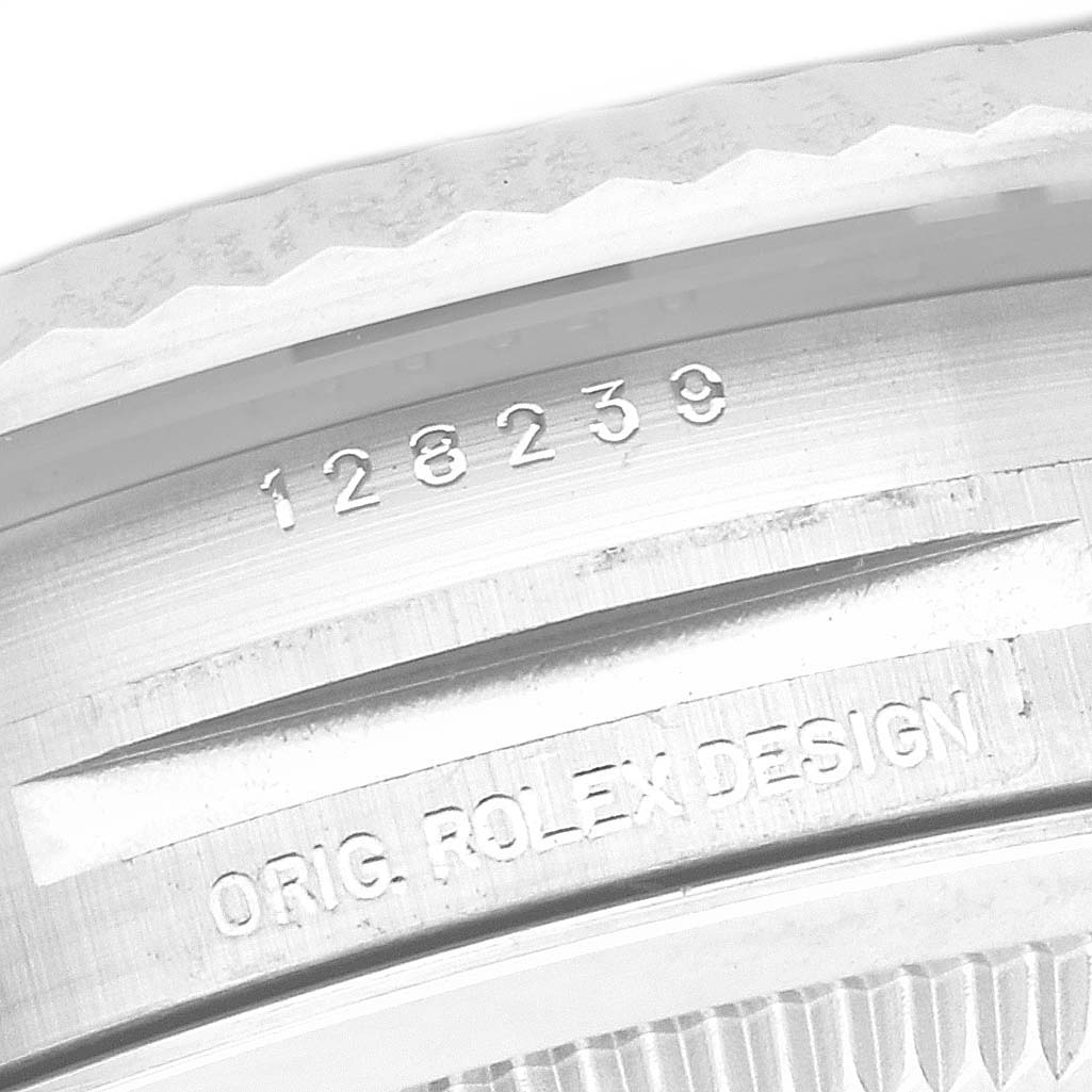 The image shows a close-up of the side of a Rolex President 128239 Men's White Gold Blue Dial 128239 Men's White Gold Blue Dial model, displaying the engravings and part of the watch case.