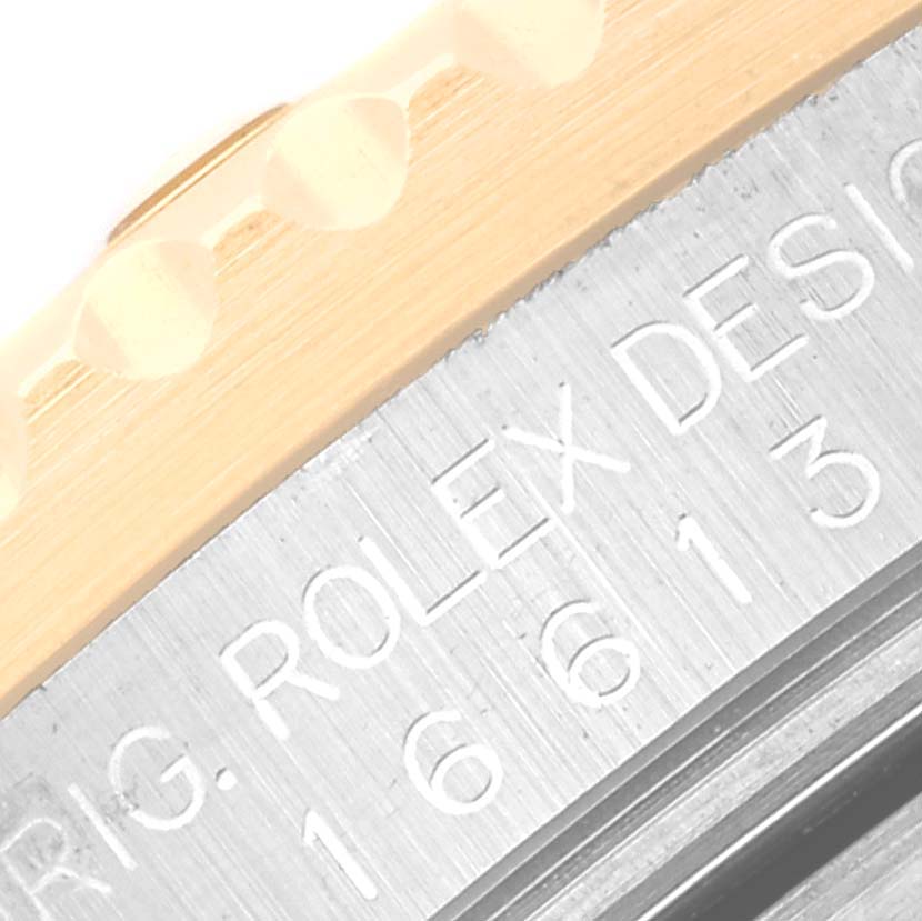This close-up image shows the side engraving and part of the bezel of a Rolex Submariner 16613 Men's Steel and Gold (two tone) Blue Dial 16613 Men's Steel and Gold (two tone) Blue Dial watch.