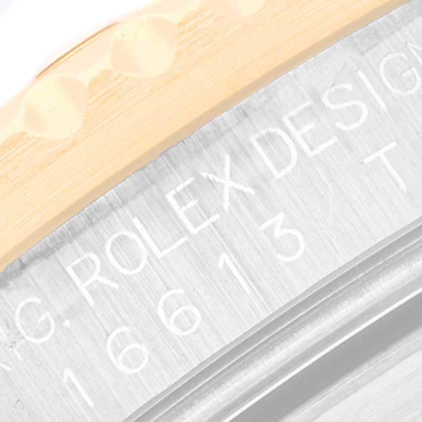 The image shows a macro view of the case and bezel engraving on a Rolex Submariner 16613T Men
s Steel and Gold (two tone) Blue Dial 16613T Men
s Steel and Gold (two tone) Blue Dial watch.