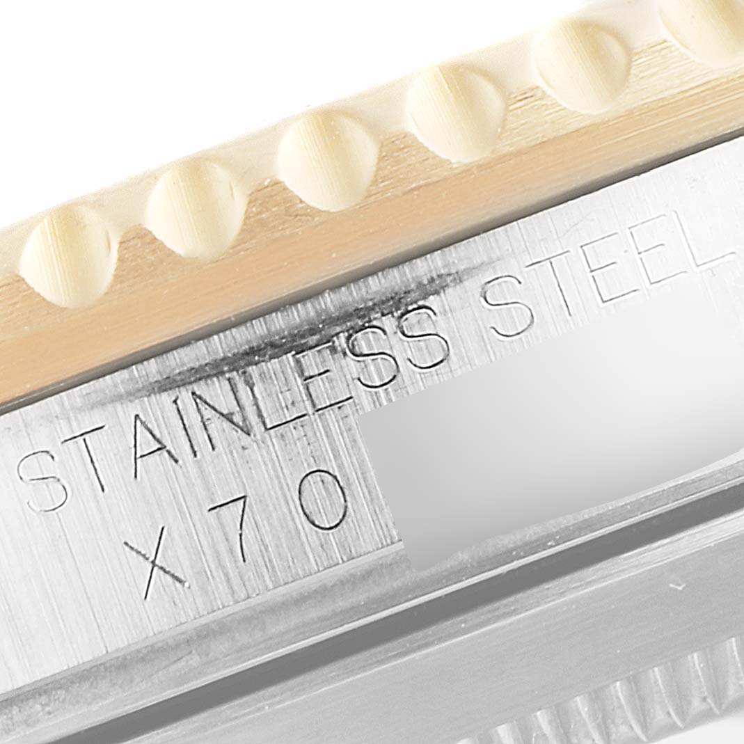 This close-up image shows the edge of the bezel and part of the engraved case back of a Rolex Submariner 16613 Men
s Steel and Gold (two tone) Blue Dial 16613 Men
s Steel and Gold (two tone) Blue Dial watch.